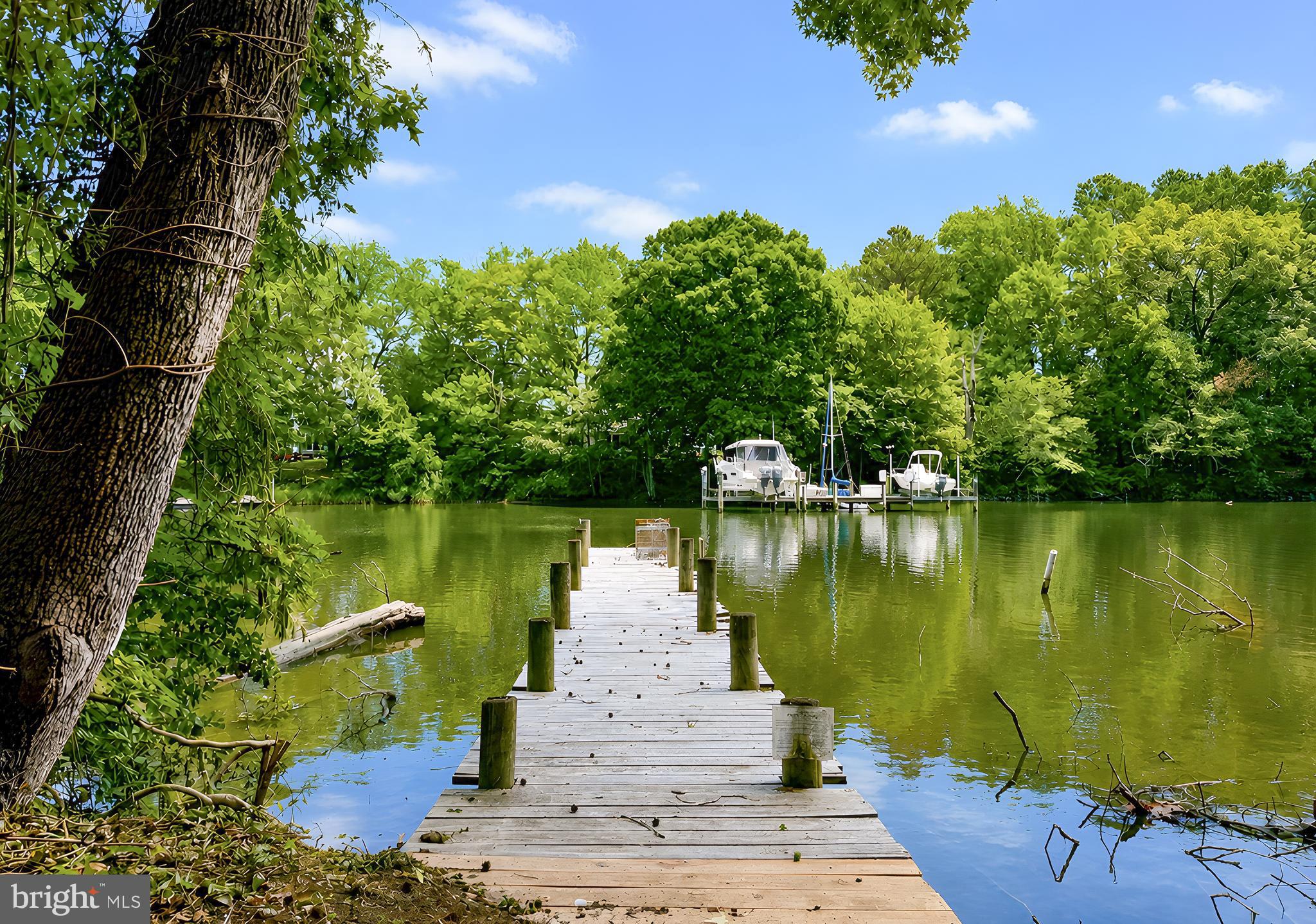 Waterfront on Smith Creek! Just in time for summer fun, this waterfront rambler, with private pier, will have you fishing and crabbing from morning until night. Hardwood flooring greets you upon entering and flows throughout most of the main level.  Tilt-out windows and a screened porch ideal for relaxing and enjoying all the sights of living on the water. New paint and ceiling fans throughout add a fresh new look. All the electric upstairs has been replaced. Roof is 2 years old. Septic is newer to include drain-fields and distribution box. Washer and dryer and well pump are 2-3 years old.  The basement is unfinished and a blank canvas to make your own.  Situated on a shaded lot with approximately 100 feet of waterfront, the property also features a paved driveway, generous parking, and a handicap-accessible ramp. Tucked away on a quiet dead-end street, yet conveniently located near Webster Field, this all-electric home offers privacy, comfort, and plenty of potential. Come see everything this waterfront property has to offer!  Additionally, this home is not in the flood plain.