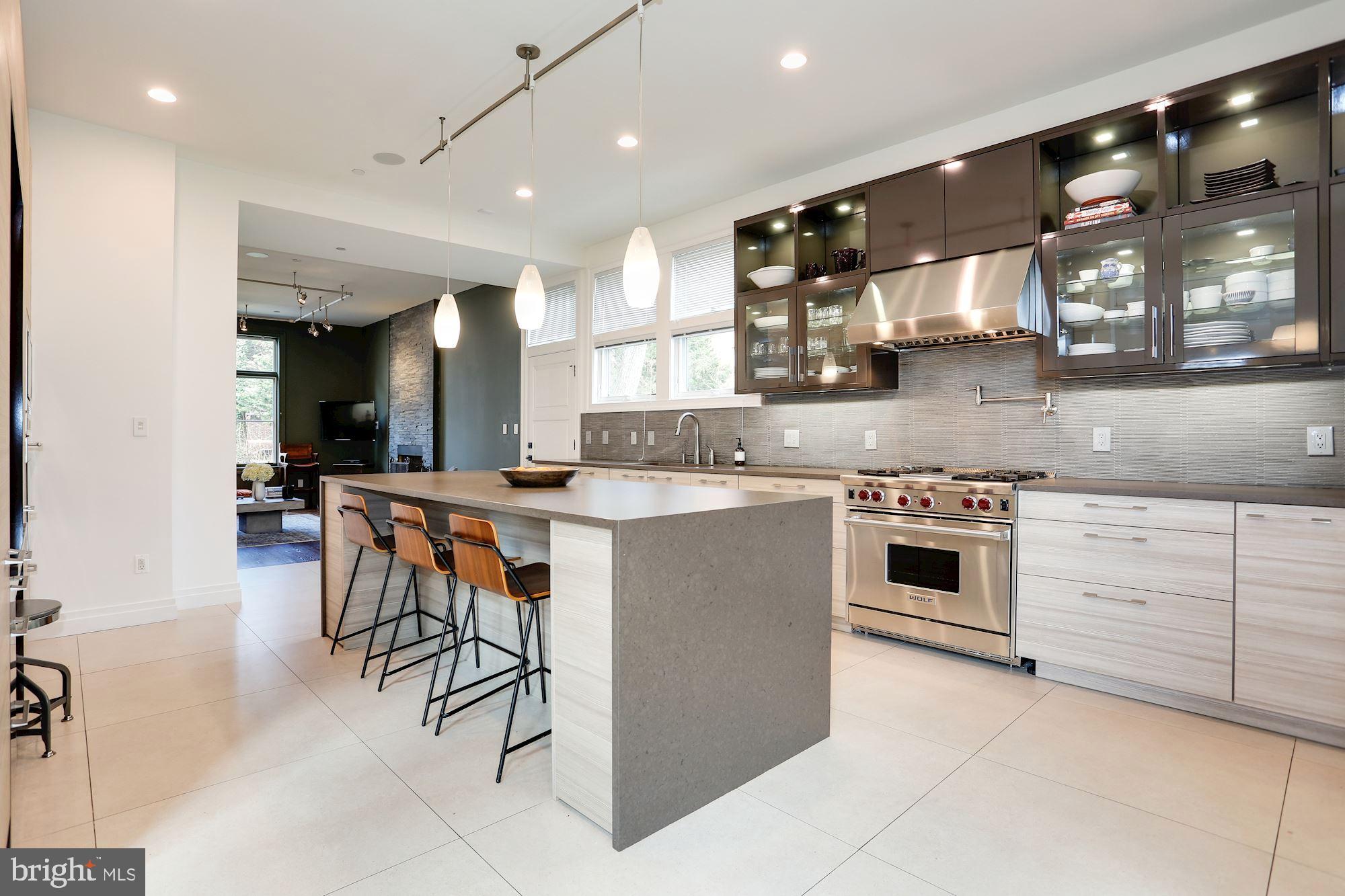This gracious home, situated on a private street in the heart of Palisades, offers tremendous space and seasonal views of the nearby C&O Canal and Potomac River. High ceilings, custom millwork and gleaming hardwood floors can be found throughout this stunning residence which boasts more than 6,000 interior square feet and an elevator that serves three floors. Two porches running the length of the house provide the ideal setting to enjoy the tranquil surroundings. The stunning main level features large and open rooms including a formal living room complete with a fireplace and two sets of French doors that look out on the park-like setting, a bright dining room with a wall of windows overlooking an outdoor terrace and a private office with custom pocket doors. There is also a chef's kitchen with eat-in table space and top of the line appliances, a family room with a fireplace, a custom wet bar, and a powder room. The first upper level features a spacious master bedroom suite with a sleek bathroom complete with steam shower and access to a walk out porch as well as three additional bedrooms all with large closets and en suite bathrooms.  The second upper level has two extremely spacious and light filled rooms and a full bathroom. The lower level has a large family room, bedroom with en suite bath and a hall powder room as well as an expansive laundry room with access to an oversized two car garage with ample storage space. This spectacular home is a short walk to MacArthur Boulevard's celebrated shops and restaurants and a short drive to downtown Washington, Virginia and Maryland.