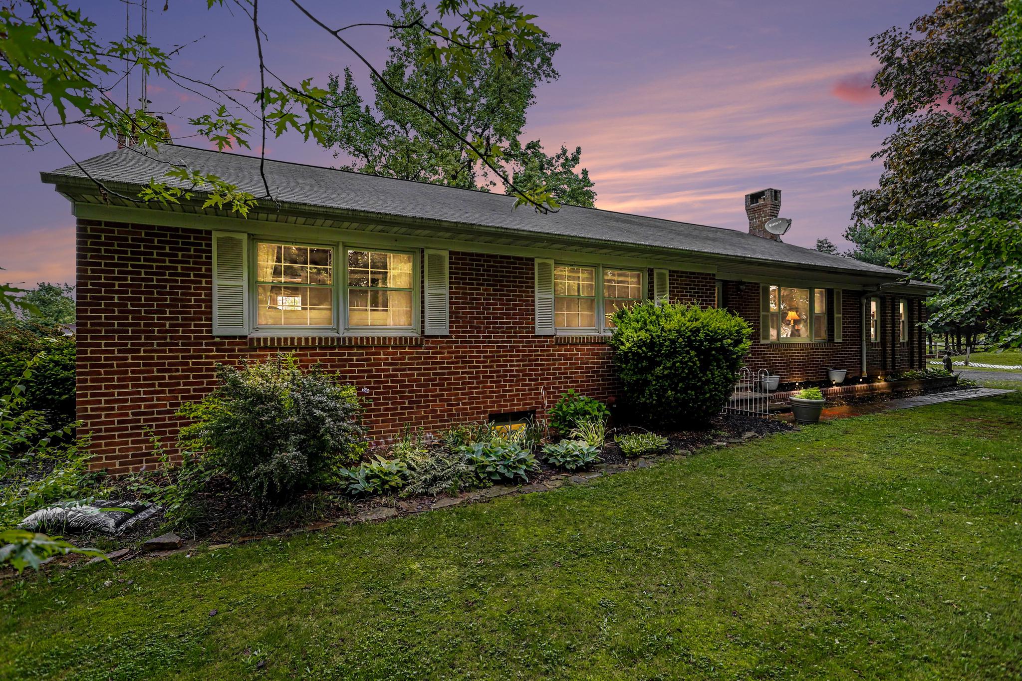 Welcome to 2226 Harney Road. This rural retreat sits on nearly 5 acres with picturesque mountain views and landscapes. The front yard is lined with mature trees providing tons of shade and allowing for outdoor relaxation. From the front entrance you are welcomed into a living room with a pellet stove. Beautiful hardwood floors span across the entire main level. The eat in kitchen has stainless steel appliances, a propane gas range, updated lighting and plenty of room for a large island. The oversized primary bedroom has a fireplace, storage space and an attached full bathroom. Two additional bedrooms and another full bathroom complete the main level. The basement is finished with tile floors, an additional fireplace, half bathroom and a large multipurpose area. The home has a full house generator, and brand-new roof has just been installed. The backyard has a covered patio area and tons of space for gardening. The property has a horse barn with stalls for 3 horses that have electric and water as well. Plus 2 outbuildings (feed shed, storage, etc.) Conveniently located with easy access to Littlestown, Hanover, Gettysburg and Taneytown.