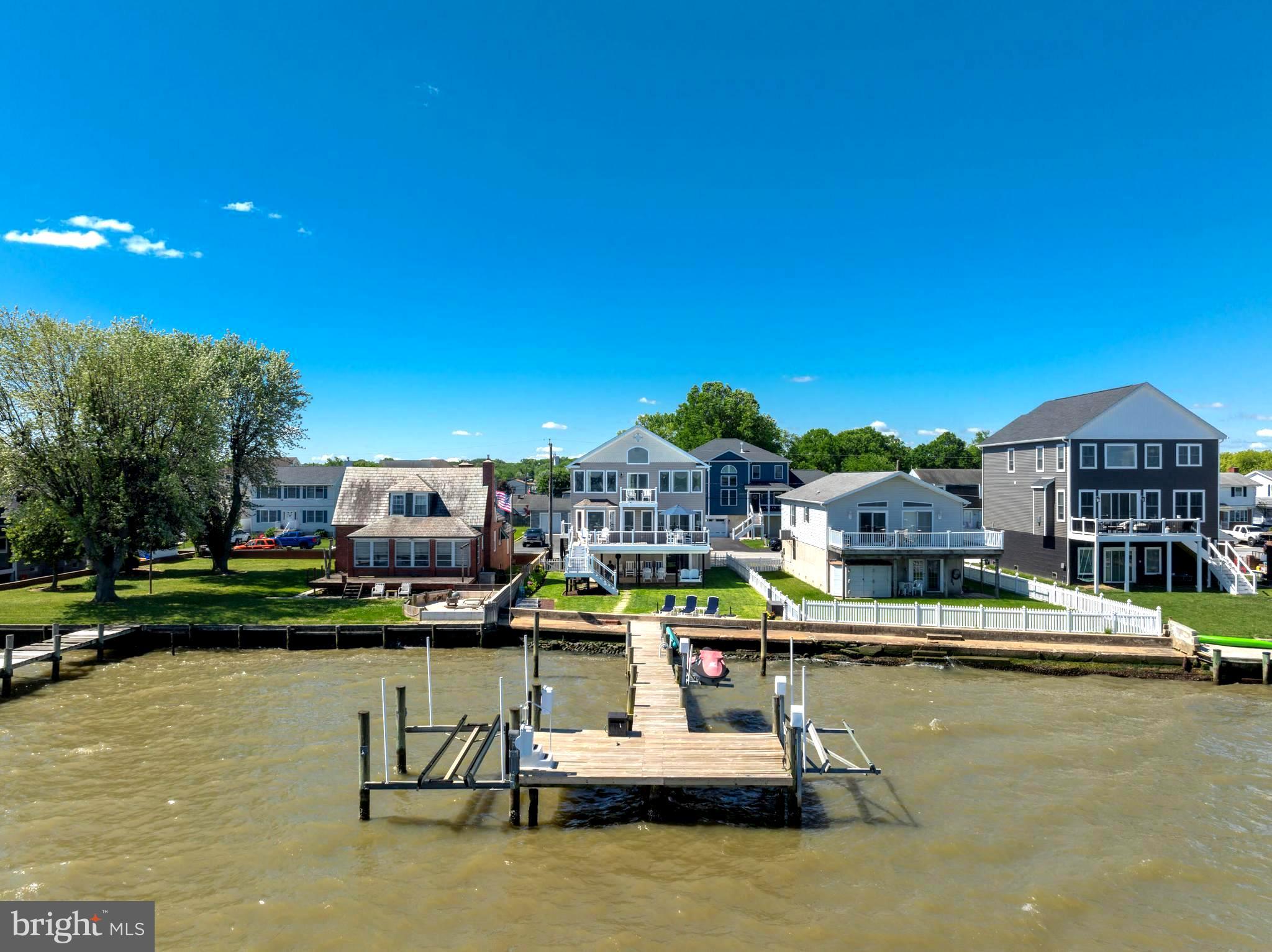 **Welcome to 7112 River Drive Road, a meticulously maintained waterfront retreat offering nearly 4,000 square feet of total space and breathtaking panoramic views that take center stage from nearly every room. Combining luxury updates, exceptional boating amenities, and thoughtfully designed indoor and outdoor living spaces, this extraordinary home delivers the ultimate lifestyle.
From the moment you step inside, soaring ceilings, gleaming hardwood floors, and expansive windows draw your attention to the spectacular water views. Natural light fills the home, while the family room offers a cozy gas fireplace and built-in surround sound, creating an inviting setting for both everyday living and entertaining.
The beautifully updated kitchen features Quartz countertops, recessed lighting, abundant cabinetry, an undermount sink, center island with storage, and Samsung Smart appliances installed in 2021, including a tablet-style refrigerator with water dispenser and ice maker. A 2026 kitchen addition created a charming breakfast nook where you can enjoy your morning coffee while taking in the tranquil waterfront scenery. Andersen sliding glass doors with built-in blinds, installed in 2023, open to a maintenance-free walk-down composite deck, seamlessly blending indoor and outdoor living.
The main level also includes two bedrooms, a full bath with porcelain tub from the original home, a laundry room with Smart LG washer, second washer (SideKick), and Smart dryer.
Upstairs, double doors lead to the luxurious primary suite, where oversized windows continue to showcase stunning waterfront views. This spacious retreat offers vaulted ceilings, brand-new carpet, a sitting area, a custom walk-in closet, and a private composite deck overlooking the water. The newly remodeled spa-inspired en-suite bath features a walk-in shower, freestanding soaking tub, double vanity, Smart LED mirror, Bluetooth exhaust fan, and a Smart toilet with bidet, heated seat, and auto-flush functions.
A previously unfinished attic has been transformed into a fourth bedroom/bonus room with new carpet, recessed lighting, updated electrical, built-in storage, and closet.
Outside, boating enthusiasts will appreciate the impressive 80-foot T-pier with water, electric, 30-amp shore power, two boat lifts (12,500 lb. w/Gem remote and 3,500 lb.), and a 1,500 lb. jet ski lift. 3 ft MLW and a hard sandy bottom, this property is ideal for boating, fishing, and water recreation. On clear days, the sellers note you can see the Eastern Shore from the end of the pier.
Additional features include concrete bulkhead, under-deck drainage, two sheds with maintenance-free platforms, a Polywood swing overlooking the water, a two-car attached garage, tankless gas water heater, Nest thermostat, generator hookup, fresh interior paint (2023), sealed driveway (2024), new shutters, front door, chandeliers, Hunter ceiling fans, and updated exterior lighting. The pier was redecked in 2020 with new end caps and hurricane straps added in 2024.
Flood insurance is only $565 annually. 
This exceptional property offers easy access to waterfront dining, fishing, and endless boating adventures. Experience the unmatched beauty of waterfront living and schedule your private tour today.