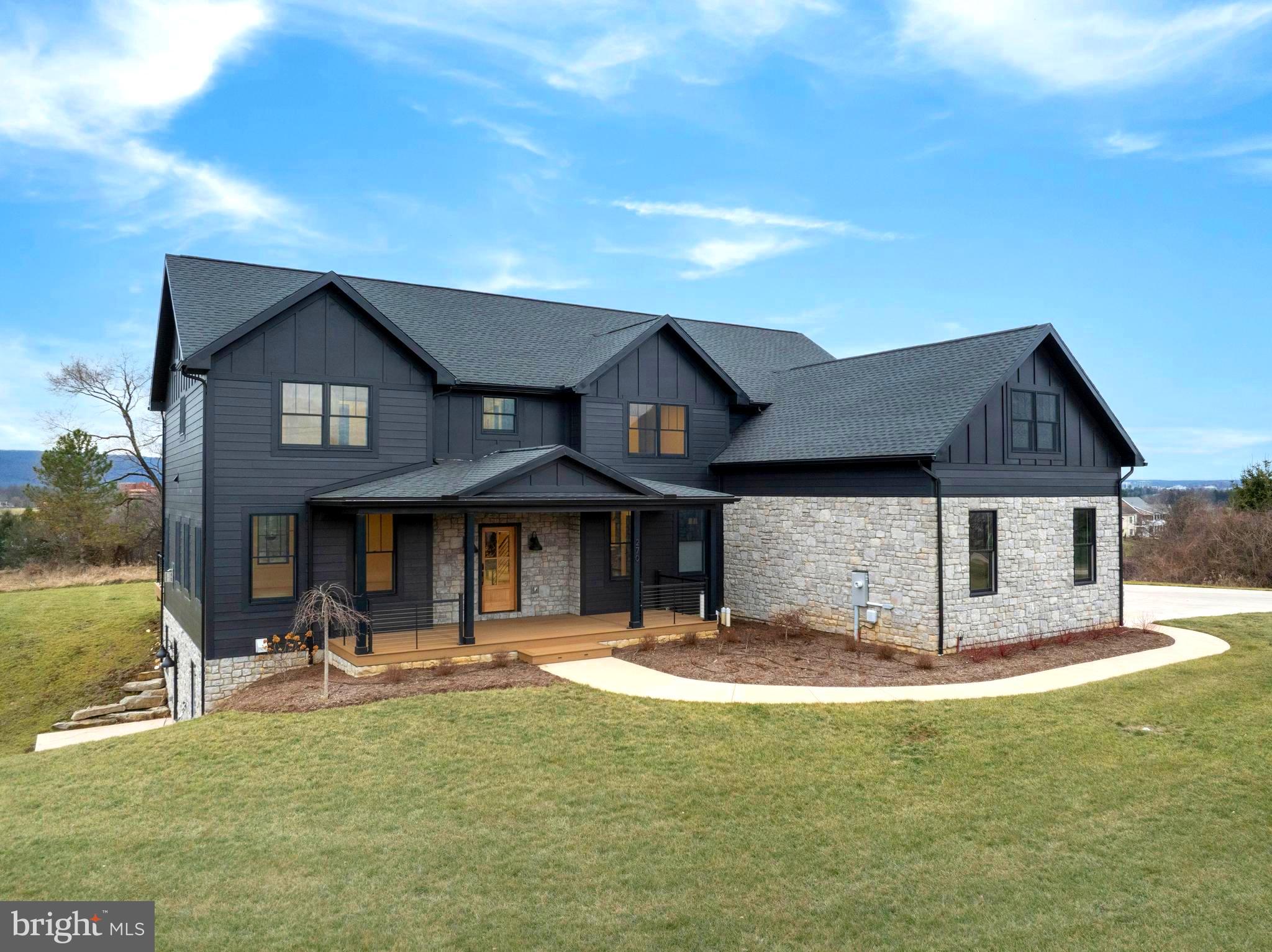 Experience refined luxury and modern elegance in this stunning 5-bedroom, 4.5-bath contemporary home situated on 2.1 acres with breathtaking views of PSU stadium, Mount Nittany and Tussey Mountain. With over 4,000 square feet of meticulously designed living space, this two-story home showcases exceptional craftsmanship, high-end finishes, and smart technology throughout. The exterior features Hardi plank siding with stone accents, custom black windows, a lighted front porch & back deck, an underground propane system for the kitchen range, grill, and fireplace, and a spacious 3-car garage. Inside, the open-concept main level highlights a gourmet kitchen with custom cabinetry, quartz countertops, a 14-foot island, pot filler, luxury appliances, and a reverse osmosis water system. The living and dining area offers a gas fireplace, herringbone white oak hardwood flooring, custom built-ins, and a cozy window bench. The upper level features four spacious bedrooms and three full bathrooms, including an impressive owner’s suite with hardwood flooring, custom built-ins, a 3–4 season enclosed patio overlooking downtown State College, a spa-like bath with heated floors, soaking tub, quartz vanity, and an expansive walk-in dressing area. Bedrooms two and three share a stylish Jack and Jill bath, while the fourth bedroom enjoys its own private bath and mountain views. The walk-out lower level provides additional living space with LVT flooring, a wet bar with two beverage fridges, a full tile bath with quartz vanity, and a private bedroom—ideal for guests or extended family. Outdoor living is unmatched with a composite back deck featuring a built-in kitchen with stone countertops, grill, and high-BTU burner. Additional highlights include a water softener, upgraded reverse osmosis system for all cold-water taps, configurable irrigation, and smart home features such as Lutron lighting, Lockly fingerprint locks, and app-supported garage doors. Every detail at 270 Claremont Avenue has been thoughtfully designed to offer luxury, comfort, and convenience in one extraordinary home. Photos have been virtually staged.