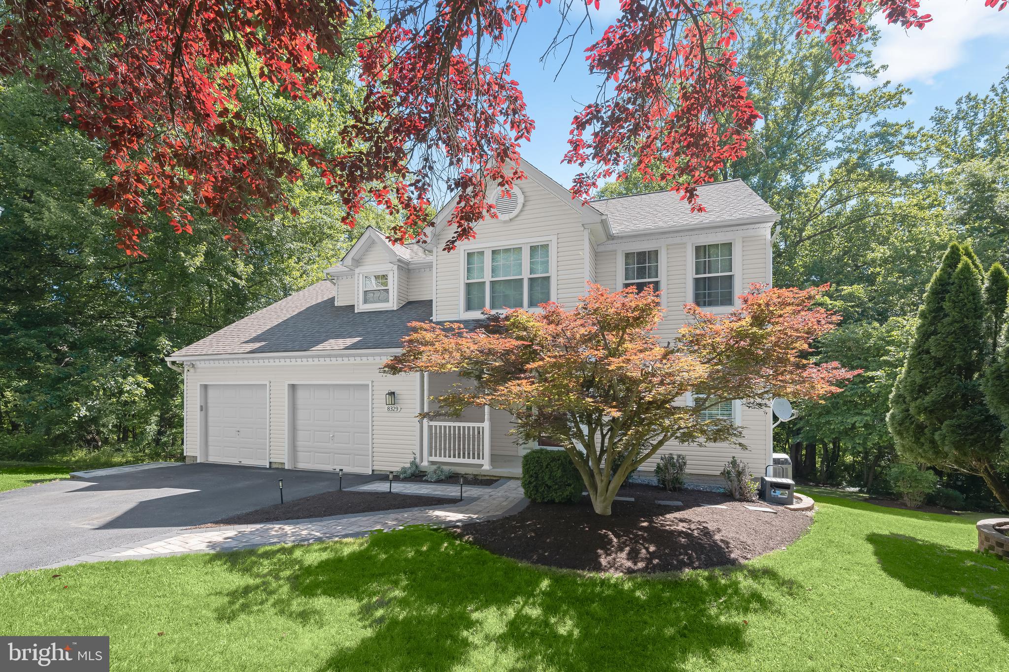 Introducing this spectacular home in the sought-after Manorwood neighborhood of Columbia, tucked away on a private shared driveway at the end of a quiet cul-de-sac backing to lush greenery and protected wetlands. Offering five bedrooms and three and a half bathrooms across three finished levels, this beautifully updated home provides abundant space for comfortable everyday living and effortless entertaining. As you arrive, manicured landscaping and a covered front porch create a warm welcome. Inside, the sun-filled main level showcases maple engineered hardwood flooring while the inviting front living room and adjacent dining room feature elegant trim moldings. The remodeled kitchen is equipped with granite countertops, a stylish tile backsplash, shaker cabinetry, stainless steel appliances, a pantry, center island, recessed lighting, and a cozy breakfast nook for casual dining. Gather in the impressive two-story family room highlighted by a soaring vaulted ceiling with skylights, a wood-burning fireplace, and sliding glass doors with built-in blinds that open to the expansive rear deck. Completing the main level are a half bathroom and access to the two-car garage. Upstairs, the primary bedroom suite boasts a walk-in closet and a luxurious en-suite bathroom with a freestanding soaking tub, walk-in shower, and dual-sink vanity. Also on the upper level are two additional bedrooms, a full hall bathroom, and a versatile loft that can easily be converted into a fourth bedroom. Downstairs, the finished lower level adds even more flexible living space with a large recreation room featuring sliding glass doors to the backyard. A fifth bedroom  and a third full bathroom also make this level ideal for overnight guests, extended family, or a private home office. Two storage rooms and a dedicated laundry room add everyday convenience. The outdoor living spaces are equally impressive with a spacious deck that spans the entire width of the home with ample room for relaxing and entertaining. Below, a paver patio overlooks the expansive backyard, creating the perfect setting for gatherings or peaceful evenings outdoors. Enjoy the tranquility of backing to mature woods and protected wetlands that cannot be developed, while remaining just minutes from shopping, dining, parks, commuter routes, and everything Columbia has to offer, with no Columbia Association fees. Beautifully updated throughout, the home also offers peace of mind with major improvements, including new Anderson windows in 2021, a new roof replaced in 2014 and an HVAC system installed in 2018 featuring a brand-new compressor and a full service completed this summer.