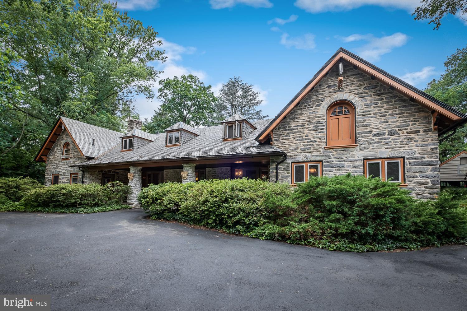 Magnificent Victorian Carriage House with over 3,600 interior square feet walking distance to train, schools and town. Crafted of stone and slate and set back on 1.89 park-like acres, this truly one-of-a-kind property is located in Philadelphia's historic Main Line and maintains much of its original architecture. Mature landscaping and lovely gardens surround the home, along with a large pond with arched bridge off the back patio, all creating the most idyllic and private environment. Enter the property via a long, private driveway and you are greeted with a wide front porch with impressive stone columns and two large pews to sit and enjoy the view. The home's first floor is quite expansive, with an open Living Room and Dining Room flooded with light from ceiling height doors and windows, and featuring gardens on all sides. On one end of this large space is the Kitchen, Mud Room, Laundry and Powder Room; at the other is a Den and/or playroom plus another incredible room with sunny views of the huge property that can be used as a home office with a private entrance.  Also from this end of the home are back stairs with additional access to the upper level. Upstairs you will find a total of four bedrooms and two baths, one of which is the current Master Bedroom with access to both wings of the house. In addition to the existing 4 bedrooms, the original and unfinished 36x16' hayloft with pitched, beamed ceiling could be finished for a spectacular Master Bedroom with a cupola skylight (see rendering included in photos). This one of a kind home backs up to the green space of the Merion Tribute House, is located in the blue ribbon/nationally-ranked Lower Merion School District and it is just a 1 block walk to Merion Elementary or 1 block to the Septa Merion Station which is just a 15 minute ride to Center City. It is also a 10 minute walk on sidewalks to the quaint town of Narberth with all of its shops and restaurants. It is unusual to find such a private country-like retreat so close to town and walking distance to so many amenities.  The potential of the property is extraordinary. This is truly a once-in-a-lifetime opportunity for the buyer who demands a very special location, a unique home and has the vision to create a masterpiece for their lifestyle.