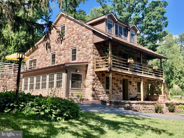 THIS PROPERTY IS GOING TO AUCTION ON SATURDAY AUGUST 8, 2026 @ 10:00 AM. THE LIST PRICE ONLY REFLECTS THE SUGGESTED STARTING BID. Outstanding rural property with valuable amenities throughout! Custom built stone and vinyl Colonial style home plus a 3-bay garage/bank barn on a secluded, partially wooded 11.20 acre tract. Main floor features a kitchen with rustic wood cabinetry, exposed beams, breakfast nook; sitting area with brick fireplace; primary bedroom with private bath; laundry; half bath; entry room with a brick floor and Columbia wood stove. Second level offers 2 additional bedrooms, full bathroom, and insulated, unfinished bonus room. Finished lower level features an in-law suite with kitchen, dinette area, sunroom, bedroom, full bathroom, and hardwood flooring. 2-story, 3-bay garage/bank barn/shop with inviting covered front porch; nice paved driveway parking area. Central A/C, heat pump, mini-split systems, on-site well and septic. One-of-a-kind, must-see showplace property with stone walls and perennial gardens!