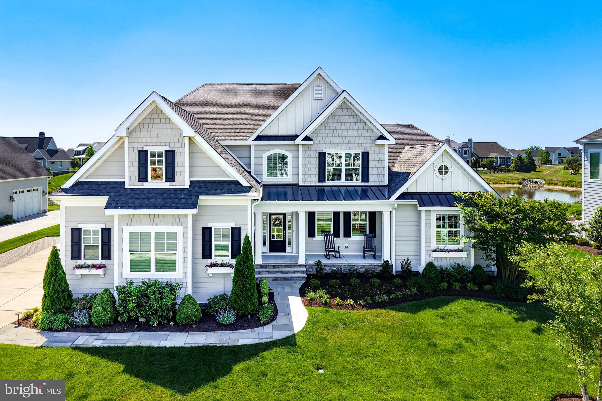 COASTAL SOPHISTICATION MEETS POND-SIDE SERENITY IN SHOWFIELD. Situated in the highly sought-after community of Showfield, this exceptional Chesapeake model by Schell Brothers offers luxury coastal living just moments from downtown Lewes, scenic trails, beaches, shopping, and dining. Perfectly positioned with a tranquil pond setting in the rear, the home enjoys added privacy and open space between neighboring properties.
Designed with both comfort and entertaining in mind, this spacious home features 5 bedrooms across the first and second floors, including a first-floor primary suite and an additional first-floor guest suite, plus a private first-floor office/flex room and a beautifully finished basement providing abundant living and recreational space.
Extensive custom upgrades elevate this home throughout, including engineered hardwood flooring with wider planks across the entire first level, expanded bump-outs, an upgraded kitchen backsplash, and an expanded driveway. The inviting front porch was thoughtfully redesigned from a traditional Trex-style porch with PVC railings into an elegant open concrete and stone porch that enhances the home’s curb appeal.
Outdoor living is truly extraordinary with professionally designed extravagant landscaping, bluestone walkways in both the front and rear, and a stunning bluestone patio anchored by a custom stacked-stone fireplace featuring symmetrical wood storage alcoves, a large tapered chimney, and a built-in natural gas grill — creating the ultimate outdoor entertaining space.
Residents of Showfield enjoy access to a beautifully appointed clubhouse offering numerous opportunities for social gatherings, activities, and community events, all within one of Lewes’ most desirable and walkable neighborhoods.