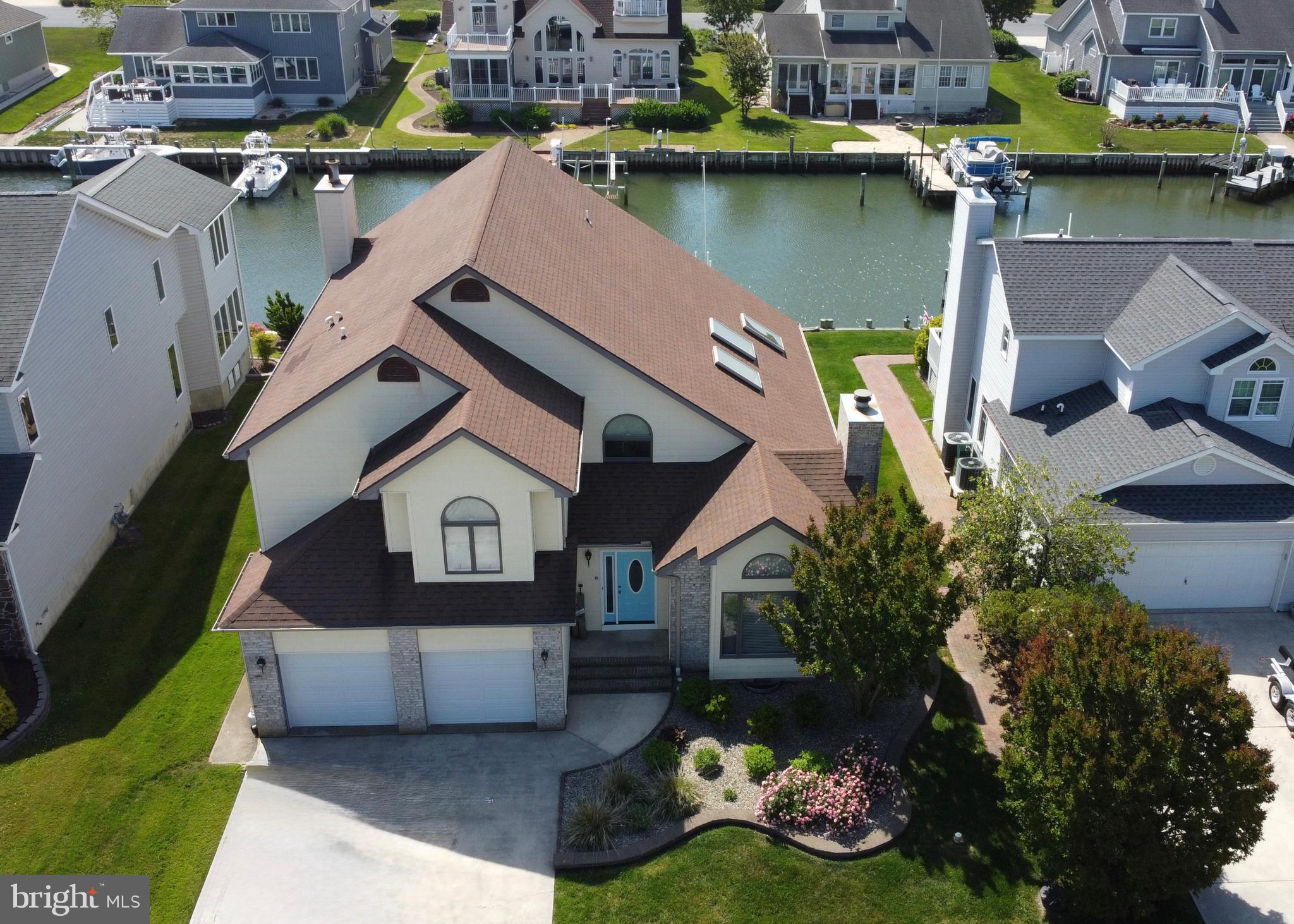 Exceptional waterfront living in sought-after Terns Landing, this elegantly updated 4-bedroom, 3.5-bath coastal residence offers refined interiors, generous gathering spaces, and direct deep-water access to the ocean with no Ocean Pines bridges to navigate.
Offered furnished and move-in ready, this inviting waterfront retreat showcases an open floor plan enhanced by cathedral ceilings, three skylights, hardwood flooring in the main living areas, and fireplaces in both the living and family rooms. The beautifully refinished kitchen is appointed with quartz countertops, new cabinetry, stainless steel appliances, large pantry and abundant workspace for effortless entertaining. Two spacious primary suites feature impressive, updated baths, including a desirable first-floor suite and a second-floor suite with access to a private deck.  Two additional oversized bedrooms with walk in closets.   A loft with built-in desk and cabinetry provides flexible space for work or overflow accompaniment.  The Florida four-season sunroom and separate three-season room create seamless options for year-round enjoyment overlooking the deep-water canal. Family and sun rooms adjoin with open concept.  Outside, beautifully landscaped grounds, a patio, vinyl bulkhead, and recently installed boat and jet ski lifts complete the waterfront lifestyle. Additional highlights include a 2-car garage, plentiful storage, walk-in closets in all bedrooms, pantry, recently replaced HVAC systems, and tankless hot water heater.  From boating, fishing, crabbing, and clamming to easy access to the Ocean Pines yacht club, golf course, clubhouse grill, pools, racquet facilities, Ocean City beach club and more.  The Ocean Pines Beach Club is located between 49th and 50th streets with private parking, pool and changing area flowing out to the beach on the Atlantic Ocean.  This home offers an exceptional opportunity to enjoy the best of coastal living and is ready for your summer enjoyment now.