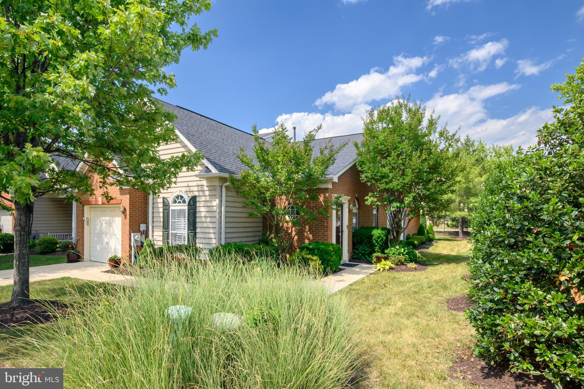 RARELY AVAILABLE and highly sought-after end-unit villa in the premier 55+ community of The Hamlets at South River Colony—where homes sell quickly! This beautiful BRICK FRONT residence offers the ease and convenience of ONE-LEVEL LIVING  in a private, no-through-street location. Step inside to an inviting OPEN CONCEPT foyer that flows seamlessly into the living and dining areas, anchored by a stunning three-sided GAS FIREPLACE that creates a warm and elegant focal point. The SPACIOUS AND BRIGHT KITCHEN features abundant upgraded classic white cabinetry, granite countertops, moderns stainless steel appliances, a center island to display the charcuterie board and beverage assortment for your guests, and space for a kitchen table too!  KING/QUEEN SIZED  primary bedroom suite offers plenty of room for all your additional furnishings, creating a comfortable retreat! The EN-SUITE BATHROOM is designed for comfort and accessibility, featuring a therapeutic walk-in bathtub/shower combination.   OVERNIGHT GUESTS will love the second bedroom conveniently located near a second full bathroom or for use as a home office, or hobby space. The LAUNDRY ROOM is complete with newer washer and dryer, is conveniently situated near the garage for everyday ease.  Just off the kitchen, the EXPANDED SUNROOM  is filled with natural light and opens through French doors to a private, fenced stone patio—perfect for relaxing with your morning coffee or entertaining guests outdoors.  Additional highlights include a one-car GARAGE plus many RECENT UPGRADES: newer roof, hardwood flooring in the living and dining rooms, wall-to-wall carpeting in the bedrooms, neutral designer paint throughout, pull-down attic storage, and a stone patio.  Ideally located just minutes from shopping, restaurants, theaters, parks, recreation, and only 15 minutes from Historic Downtown Annapolis. Don't miss this exceptional opportunity to enjoy low-maintenance living in one of the area's most desirable active-adult communities!