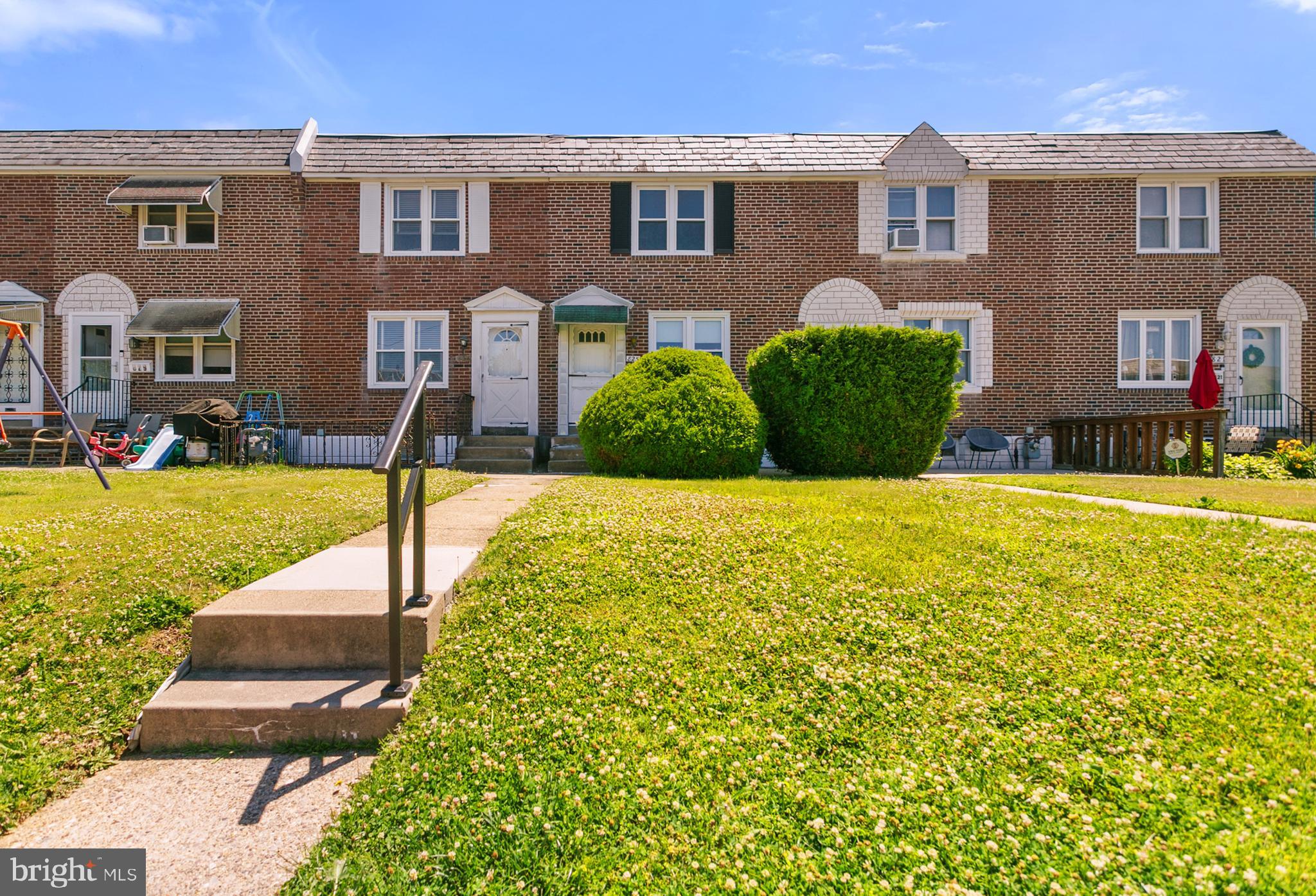 ***OPEN HOUSE! Thursday, June 18th from 4:00 PM–6:00 PM*** ... Welcome Home to 825 Surrey Lane! Nestled in the heart of the highly desirable Briarcliffe section of Glenolden, this charming rowhome has been lovingly cared for by the same owner for more than 50 years and is now ready to welcome its next owner.
As you arrive, you'll appreciate the warmth of the neighborhood. The walkway will lead you to the front patio, where mature privacy bushes create a peaceful space to relax and unwind. Step inside and discover a home that has been meticulously maintained in move-in condition and offers a wonderful opportunity to make it your own. Beneath the carpeting, hardwood floors span the home, just waiting to be revealed and revived. The spacious living room flows seamlessly into the formal dining room, creating an ideal layout for both everyday living and entertaining. The kitchen is full of nostalgic charm and offers space for a cozy breakfast nook, additional pantry storage, or your future dream kitchen design. Upstairs, you'll find a generously-sized primary bedroom complete with a ample built-in closet space for added convenience. Two additional bedrooms and a full bath complete the second floor. The finished basement provides an opportunity for a family room, home office, gym, playroom, or work area, while still offering plenty of storage space. Outside, the fenced rear yard is perfect for your furry friends, gardening, or creating your own private outdoor oasis. The property also features a private driveway space for one vehicle, attached one-car garage, and off-street parking if needed.  If that is not enough, you will find comfort in ownership knowing the roof has been replaced within the last 10 years, the AC was installed in 2016 and the hot water heater was replaced in 2023. Are you looking for a home in a great neighborhood to make your own and add equity in the process? This is it! Do not miss out on the opportunity to own 825 Surrey Lane. Schedule your private tour today!