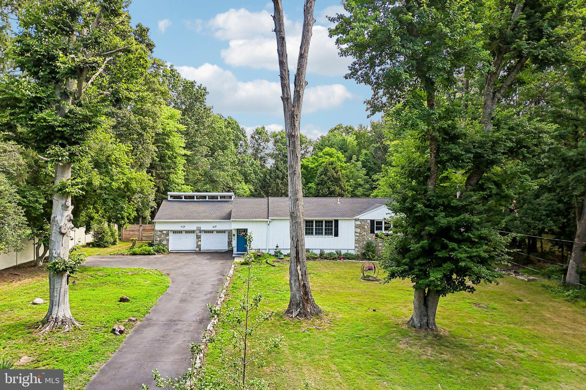 WOW! This one-of-a-kind custom stone ranch, tucked away at the end of a quiet street in Warrington Township, is an absolute must-see! Nestled at the end of a  cul-de-sac on nearly 1.25 acres of beautifully landscaped, park-like grounds, this exceptional property offers space, versatility, and modern updates throughout.
The main level of the home features 3 bedrooms and 2 full bathrooms, while the finished lower level includes a private office or optional 4th bedroom, an additional full bathroom, and laundry area. Above the oversized 2-car garage is a fully renovated office/bedroom, 1-bath in-law suite complete with its own full kitchen, separate entrance, and independent ductless mini-split heating and cooling system—perfect for extended family, guests, or flexible living arrangements.
Outside, enjoy fresh landscaping, a long private driveway, a spacious rear deck accessed from the kitchen, a large fenced backyard with a storage shed, and nearly 1.25 acres of peaceful, park-like surroundings that provide exceptional privacy and room to relax, entertain, or play.
Step inside to a bright, open-concept living room featuring custom woodwork and durable LifeProof flooring that extends throughout the main level and finished basement. The stunning kitchen offers quartz countertops, a large center island with breakfast bar seating, modern white shaker cabinetry, and ample workspace for cooking and entertaining.
The hall bathroom is beautifully finished with a subway tile shower, soaking tub, tile flooring, and built-in niche shelving. The primary suite features a luxurious en-suite bath with a large tiled shower accented by elegant marble decorative details.
The finished basement provides additional living space, a full bathroom, an optional bedroom or private office, and conveniently located laundry hookups, while also housing the home's mechanical systems.
The in-law suite has been renovated to match the quality and style of the main home, featuring LifeProof flooring, fresh paint, a full kitchen, a spacious full bathroom with a soaking tub, tiled shower, marble accents, and its own private HVAC system. Access is available through the garage or a separate exterior entrance.
The oversized garage offers two front overhead doors with automatic openers, plus side and rear access, along with a separate enclosed storage area.
Additional highlights include a new HVAC system (2024) and quality custom finishes throughout. Every detail has already been completed—simply unpack and move right in!