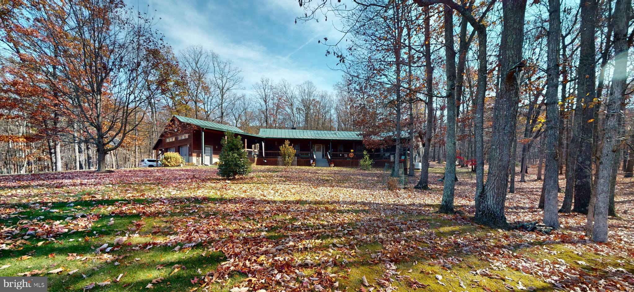 This utterly unique, custom-built, cedar-sided home is the epitome of rustic and modern elegance.  The home is situated on  25 ACRES with a large SPRNG FED POND.   The property has been immaculately kept and is truly exquisite. Your turnkey home in beautiful WV awaits!  Host family and friends in the open, modern kitchen.  With updated appliances including a gas stove, large walk-in PANTRY, large island with a second sink and solid surface counters, it truly is a culinary delight. The living room is expansive, with an stacked-stone, wood burning fireplace, an abundance of natural light and  vaulted ceilings, creating a warm and inviting ambiance.  In addition, the home dons TWO PRIMARY bedrooms each with walk-in closets and en suite bathrooms and walk-in showers.   WOW & the third bedroom has an attached Jack n Jill Bathroom.  Perfect for guests – rentals are permitted. The bonus room has variable potential as an office, gym or additional guest space. Red Oak Hardwood flooring, Ceramic Tile & Vaulted Ceilings throughout the home. Relax  on your covered front porch connecting to the 2 car climate controlled Garage and 2 car Carport.  Plenty of Covered parking! This space practically begs you to unwind in the rocking chairs.  An adorable matching shed and a meticulously fenced-in garden areas, pergola and large back deck complete the exterior.  An additional water feature can be found on the West boundary where WATERLICK Run flows and is within hearing distance of the house.  The acreage is 100% usable with towering HARDWOODS, HUCKLEBERRIES, MOSSY CARPET, MOUNTAIN VIEWS, PASTURE & TILLABLE LAND.   Flowering & Fruit Trees can be found here.  Check out a few of recent updates: whole house generator, all new heating and cooling systems, tankless propane water heater, whole house stained & decks refinished. Come see 315 Beech Lane, its not just a house but a home. This home is a true masterpiece, waiting for its new owners to fall in love with it.
