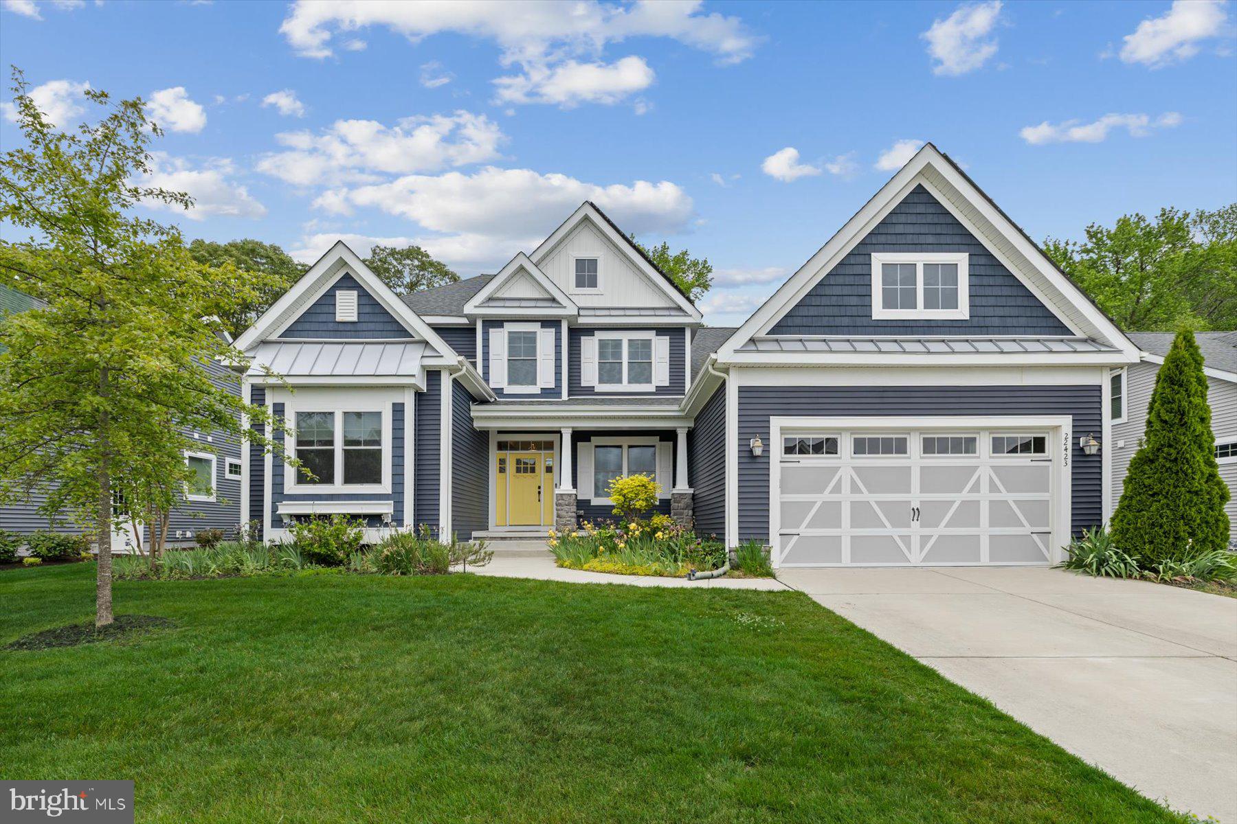 This beautiful home offers exceptional comfort, flexibility, and thoughtful upgrades throughout. The stunning Schell Whimbrel floor plan was designed with convenience and modern living in mind, featuring 4 bedrooms, a den, and 3 full baths in an impressive and functional layout.

Curb appeal shines from the moment you arrive. A welcoming front porch, coastal blue exterior, stone accents, and classic architectural lines create a timeless first impression. Situated on a desirable perimeter lot, the home enjoys peaceful wooded views and added privacy.

Inside, the open and airy living spaces are enhanced by vaulted ceilings in the great room and soaring sloped ceilings in the dining and kitchen areas. A dramatic wall of windows fills the home with natural light while showcasing the tranquil natural backdrop. The great room features a cozy gas fireplace for cool evenings and a high-end ceiling fan to keep things comfortable year-round. Rich Brazilian teak hardwood flooring adds warmth and elegance throughout the main living areas.

The chef’s kitchen is truly the heart of the home, offering an oversized island, abundant workspace, and extensive cabinetry, including decorative glass-front cabinets perfect for displaying treasured pieces. Additional highlights include a large pantry and premium stainless steel appliance package featuring a 6-burner cooktop, hood vent, double convection wall ovens, dishwasher, microwave, and refrigerator with dual ice makers. A stylish tile backsplash completes the space beautifully.

The first floor includes three bedrooms plus a den, offering flexibility for guests, work-from-home needs, or hobbies. The spacious primary suite features vaulted ceilings, a bump-out sitting area, and a large bay window overlooking peaceful natural scenery. A private door provides direct patio access. The luxurious primary bath includes both a walk-in shower and garden tub, dual vanities, and two generous walk-in closets.

Upstairs, a completely private second-floor retreat offers endless possibilities. This level includes a spacious bedroom, full bath, large living area, and an enormous storage room that could easily be finished into additional living space. Ideal for guests, a home office, studio, or hobby area.

The expanded oversized garage is a rare and valuable feature, designed with hobbyists and crafters in mind. Deep enough for multiple vehicles, motorcycles, or even boats, the space also includes its own mini-split heat pump system for heating and air conditioning. Additional features include a 220-volt outlet for EV charging, a kiln, welder, or other high-amp equipment, along with a utility sink and ceiling-mounted bicycle storage lift system.

Step outside to your private backyard oasis. The expansive paver patio offers abundant entertaining space surrounded by lush landscaping and wooded serenity. A hot tub and gas grill convey with the home, making outdoor living effortless. Wildlife sightings and peaceful scenery create the perfect place to unwind after a long day. The property also features full irrigation for both lawn and plantings.

Adding even more value, the home includes owned solar panels, complementing the already energy-efficient construction and helping reduce utility costs for years to come. 

Located in Saddle Ridge, this home places you close to everything Lewes and Rehoboth Beach have to offer, including golf, boating, fishing, crabbing, biking trails, Cape Henlopen State Park, Love Creek, shopping, dining, and the growing Route 9 corridor. Nearby Beebe Medical facilities add convenience and peace of mind. Residents enjoy outstanding community amenities, including a clubhouse with bar and pool table, meeting spaces, resort-style pool overlooking scenic ponds and fountains, covered outdoor gathering areas, fire pit, tot lot, sundeck, and community lawn care and maintenance.

This exceptional property truly combines luxury, practicality, and coastal lifestyle living in one remarkable home.