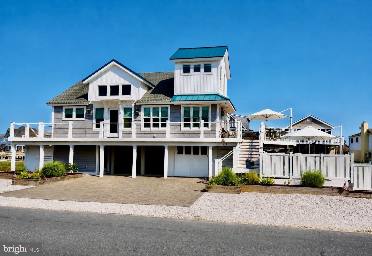 Professional photos to follow: Luxury Coastal Waterfront Living!  Perfectly positioned on the water on an oversized one-and-a-half-lot, this exquisitely renovated 4BR/3.5BA waterfront residence offers approximately 2,450 square feet of refined coastal luxury. Complete with a private pool, multiple waterfront decks, and boat lifts, this exceptional home seamlessly blends sophisticated design with the relaxed elegance of effortless waterfront living. Every detail has been thoughtfully curated to create a home that is both elegant and inviting. Flooded with natural light through expansive windows, the open-concept floor plan showcases breathtaking water views from nearly every room while offering exceptional functionality, abundant storage, and timeless finishes throughout. The heart of the home is a stunning custom chef's kitchen designed for both everyday living and grand entertaining. Outfitted with premium appliances, custom cabinetry, luxurious quartz countertops, and an impressive center island, the kitchen flows seamlessly into the family room and waterfront dining area. Whether hosting intimate dinners or lively gatherings, every space has been designed to capture the beauty of the water and the ever-changing views of boats passing by. The main level also features a luxurious waterfront primary suite, creating the perfect private retreat. The spa-inspired ensuite bath boasts a beautifully designed custom tiled shower and designer finishes, while a conveniently located powder room serves guests with ease. Upstairs, three spacious waterfront guest bedrooms provide family and friends with their own peaceful sanctuary, complemented by a beautifully appointed full bath. An expansive upper balcony offers panoramic water views, creating the ideal setting to enjoy morning coffee, breathtaking sunsets, or quiet evenings overlooking the bay. The lower level has been thoughtfully designed for coastal living with a welcoming mudroom, full laundry room, additional bath and another shower, and direct access to both the garage and waterfront. A one-car garage, along with a rear storage garage, provides ample space for kayaks, paddleboards, canoes, fishing gear, and all of your waterfront essentials.  Architectural details elevate the home's coastal elegance, including custom shiplap accents, sleek cable railings, a striking teal metal roof, maintenance-free composite decking, extensive paver hardscaping, professional landscaping, and an outdoor shower after long days at the beach or on the water. Your Private Outdoor Oasis, designed to rival the finest waterfront resorts, the outdoor living spaces are truly extraordinary. Lounge beside the sparkling private pool, gather around the fire pit beneath the stars, or entertain effortlessly in the outdoor bar area. Multiple waterfront decks provide endless places to relax and take in the spectacular views, while the expansive fenced yard offers lush green space for children and pets—a rare luxury in waterfront living. Boating enthusiasts will appreciate the 10,000-pound boat lift, floating dock, and dedicated jet ski lift, providing immediate access to the bay for days spent cruising, fishing, or enjoying life on the water. With parking for up to eight vehicles and the beach just a short 2 block stroll away, every element of this remarkable property has been designed to embrace the very best of the coastal lifestyle. 28 Oyster Bay Drive is more than a home—it is a private waterfront retreat where luxury, comfort, and unforgettable outdoor living come together to create an extraordinary coastal experience. Ideally located within walking distance of the area's favorite waterfront restaurants, charming boutiques, and local shops, you'll enjoy the perfect blend of peaceful coastal living and the convenience of having everything you need just moments from your front door.  One seller is a licensed Real Estate Agent.