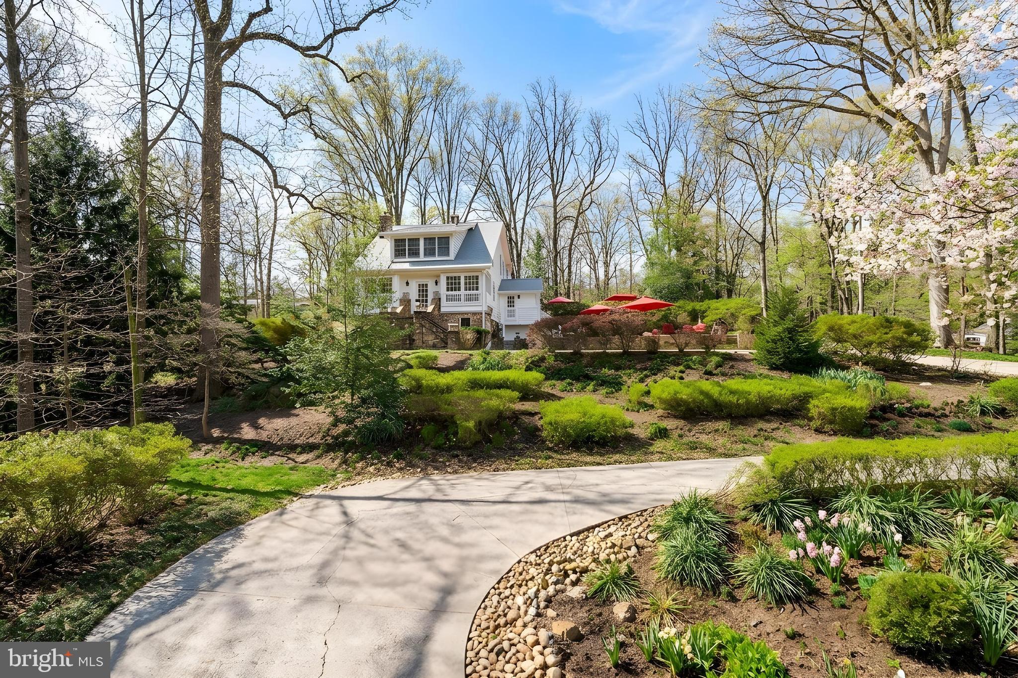 PRIVATE RETREAT with water views on one of the larges lots in Takoma Park — a storied circa 1900 manor perched above Sligo Creek on over 1.21 of gorgeous mature landscaped & wooded land, and a presence that has quietly captivated the neighborhood for generations.

You know the one. The storybook home tucked behind the winding driveway, framed by river-stone walls and a canopy of mature trees — the one you’ve driven past for years and wondered about. From the moment you arrive, the property feels transportive, more private estate than city residence, offering a rare blend of architectural history, natural beauty, and soulful design just moments from downtown Takoma Park and Washington, DC.

Rich with craftsmanship and character, the home showcases exceptional stonework, handcrafted wood detailing, and an enduring sense of artistry throughout. Originally designed and built by renowned builder Harry Spencer, whose work helped shape early Takoma Park, the residence remained in the original family for over a century — a testament to its timeless quality and remarkable stewardship.

At the heart of the home is a truly extraordinary kitchen designed by the current owner, an internationally acclaimed kitchen designer known for creating culinary spaces for some of the world’s greatest chefs. Conceived as both a professional-grade cook’s kitchen and intimate gathering space, the kitchen has hosted celebrated chefs, creatives, and Washington luminaries for decades.

The main level unfolds with luminous living spaces wrapped in windows overlooking the surrounding greenery and Sligo Creek. A striking monolithic fireplace anchors the living room, while intimate dining and sitting areas flow seamlessly toward the gardens and outdoor entertaining spaces beyond.

Upstairs, the primary suite feels suspended among the trees, offering tranquil creek views and a Japanese-inspired spa bath. Two additional bedrooms filled with natural light share a beautifully preserved Art Deco bath. The finished walk-up loft crowns the home with an airy, treehouse-like atmosphere ideal for a guest retreat, studio, meditation room, or additional lounge space.

The lower level is a standout feature unto itself — expansive, beautifully finished, and exceptionally versatile. With its own private entrance, wraparound windows, and French doors opening directly to the grounds, the space feels remarkably bright and connected to nature. Coffered ceilings, a gas fireplace, built-in shelving, generous open living areas, and a spacious bedroom suite with spa-like en-suite bath create the feel of a fully independent residence, ideal for guest quarters, multigenerational living, a creative studio, office headquarters, or wellness retreat.

Outside, the grounds unfold like a private botanical park. Multi-colored heirloom azaleas, mature trees, layered stonework, and sweeping lawns create an atmosphere that feels worlds away from city life. Unlike many homes along Sligo Creek Parkway, the property offers a rare flat, sunlit section of land adjacent to the home — ideal for a future pool, gardens, recreation, expanded entertaining spaces, or potentially a future detached ADU, subject to buyer verification and approvals. A two-tiered patio overlooking Sligo Park further enhances the home’s seamless connection to the landscape.

Directly across the street, the Sligo Creek Trail winds through the forest canopy, offering immediate access to miles of trails and nature, yet the home remains just blocks to downtown Takoma Park and approximately one mile to the DC line.

This is more than a home — it is a legacy property. A place of history, creativity, gathering, and retreat unlike anything else in the region. NEW ROOF & NEW tankless water heater (2026)
