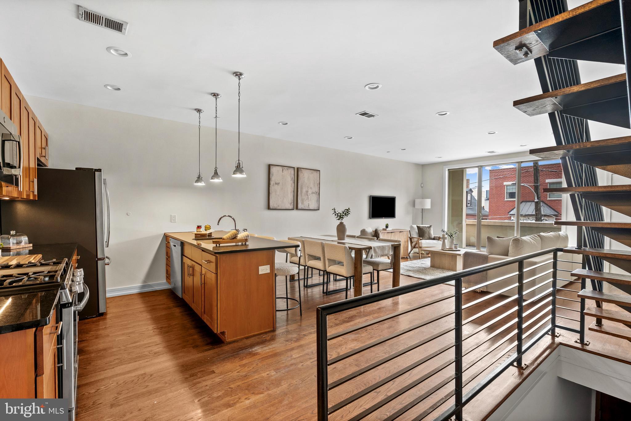Welcome to a sun-drenched, bi-level condominium that delivers the space, layout, and outdoor living today’s buyers are searching for, all within the highly sought-after Adaire School catchment. This expansive 3-bedroom, 3-bath home offers an exceptional sense of scale, highlighted by a massive open-concept living and dining area that truly sets it apart from the typical condo layout. The main level is designed for both everyday living and entertaining, featuring a sleek kitchen with granite countertops, stainless steel appliances, and a large breakfast bar that flows seamlessly into the oversized living space. Flooded with natural light and anchored by glass doors leading to one of three private outdoor areas, this level also includes a full bathroom for added convenience and flexibility. Upstairs, you’ll find two generously sized bedrooms and two well-appointed bathrooms, offering ideal separation of space for guests, a home office, or additional living arrangements. A wide staircase leads to the true showstopper: an incredible private roof deck with sweeping 360-degree skyline views, providing the ultimate setting for entertaining, relaxing, or unwinding above the city. Located in the heart of Fishtown, just steps from Frankford Avenue and surrounded by some of Philadelphia’s best restaurants, cafes, and nightlife, this home combines prime location with rare interior volume and unmatched outdoor space. Schedule your showing today!