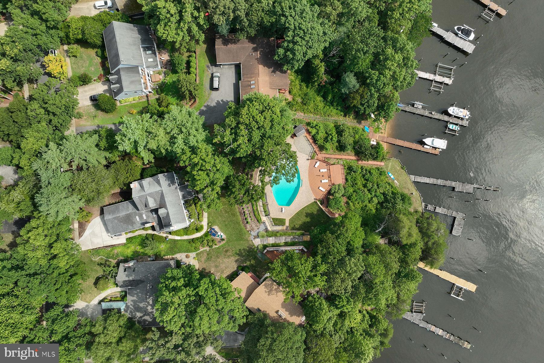 INCREDIBLE OPPORTUNITY to enjoy one of the finest waterfront properties in Annapolis: 365 and 367 Broadview Lane in desirable Broadview Estates are being sold together. 367 Broadview Lane is a 1930 waterfront home that has had multiple updates by the current owners, including several bathrooms, the kitchen, tankless water heater, and the installation of a sauna. This lot includes a private pier with 4+ ft water depth. 365 Broadview Lane is a separate parcel that features one of the most spectacular pools in Anne Arundel County, with gorgeous paver patio and recently replaced decking and retaining walls. This lot also has a private pier on Broad Creek and an unfinished “bonus room” under the main pool deck. Together, these properties create an unforgettable waterfront experience.
The home has a gracious floor plan, with formal dining and living rooms – flanking the original foyer – facing the water. The living room offers a gas fireplace and pretty glass doors transition to the family room. A waterside porch offers a serene dining experience with concord grape vines as the “ceiling.” The renovated kitchen is steps from a huge family room, with vaulted ceiling, gas fireplace, and skylights.  There is a mudroom with tons of storage, and a wet bar that facilitates the morning coffee. Beautiful hardwood floors and 5-panel doors in most rooms. The home offers three bedrooms on the second floor, including a primary suite that has a large sitting room with gas fireplace, jetted tub and Broad Creek Views. The other two bedrooms on this level share a renovated bathroom and have water views. There is a 4th bedroom, with bathroom and sitting room, on the top level. There is also a full bath on the main level, and a shower and sauna on the lower level. Broadview Estates is in an excellent location off Riva Road, and there is public water, sewer, and natural gas in the community. PLEASE DO NOT WALK ON PROPERTY WITHOUT AN APPOINTMENT.