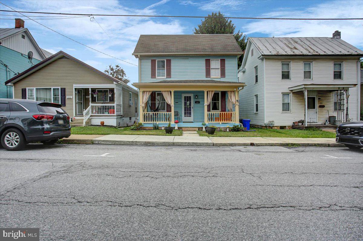 Nestled on a quiet street with ample parking, this 4-bedroom home perfectly blends comfort and convenience. Enjoy the best of downtown living, just minutes from Shippensburg University, local shopping, dining, grocery stores, I-81, and the local elementary school. Step onto the cozy front porch, an inviting space perfect for your morning coffee or evening relaxation. Inside, the main level features durable, newer LVP flooring throughout, a convenient half bath with laundry, and a first-floor bedroom. The kitchen boasts an attached storage room that leads to the backyard, ideal for keeping bulky appliances tucked away. Upstairs, you'll find three additional bedrooms, including a generous primary bedroom with direct access to a large attic for all your storage needs. The second floor also features a large, recently updated full bath with plenty of storage. The fully fenced backyard features a brick patio, a stone fire pit, and a large storage shed. Best of all, the rear of the property includes alley-accessible parking that comfortably accommodates up to three vehicles. Don't miss out on this move-in-ready gem!