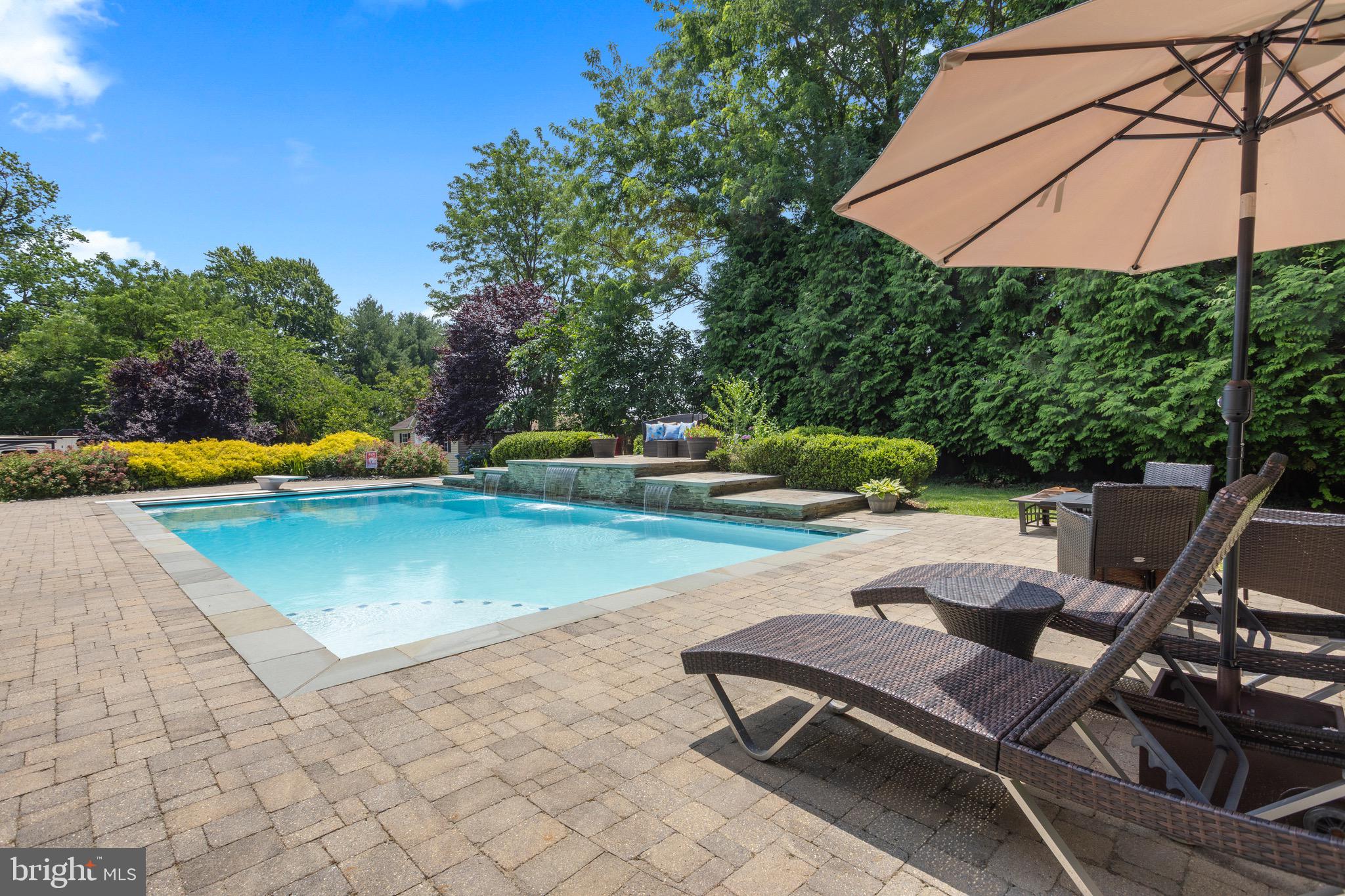 This spacious QBH custom built Colonial offers over 5,000 square feet of living space with 5 bedrooms, 4.5 bathrooms, an extra lot that conveys, and no HOA! Thoughtfully updated throughout, this home features a new HVAC system in 2021, brand-new carpet, newer appliances including a dishwasher and refrigerator replaced in 2025, microwave replaced in 2023, plus the washer and dryer. The main level offers a spacious office, perfect for working from home, and a beautiful kitchen with granite countertops, a large island, and plenty of room for a farmhouse table. The primary suite is a true retreat with a large sitting area, walk-in closet, walk-in tiled shower, and soaking Jacuzzi tub. Upstairs, one bedroom includes a private bathroom, while two additional bedrooms share a convenient Jack-and-Jill bath. The finished basement offers 9-foot ceilings, a built-in bar, the fifth bedroom, a full bathroom, and an additional flex space ideal for a workout room, art studio, office, or playroom. The fully fenced backyard is an outdoor oasis- resort style living features an in-ground heated saltwater pool with an electric pool cover, propane pool heater, waterfalls, lights, and updated pool equipment (including a pool pump and filter replaced in 2024, waterfall pump replaced in 2025, and new pool cleaner in 2026). Enjoy the deck with a retractable awning for added shade, outdoor kitchen with a propane grill (connected to the main propane system), an in-ground sprinkler system, landscaping lights, and tint on all back-facing windows, including the slider, to help with efficiency and comfort. Beautiful landscaping surrounds the property with lilies, hydrangeas, and more. Additional features include a dual active radon mitigation system, installed security system (that could be connected), 12x20 shed with 6x6 double doors, ramp, and dormers, plus a gravel pad perfect for RV, boat, or trailer parking. Town residents enjoy private access to Bay Front Park, also known as Brownie’s Beach, along with nearby walking paths on the Chesapeake Beach Railway Trail. With updated systems, incredible outdoor amenities, extra parking, an additional lot (totaling .96 acre), and no HOA, this home offers space, flexibility, and so much to love.