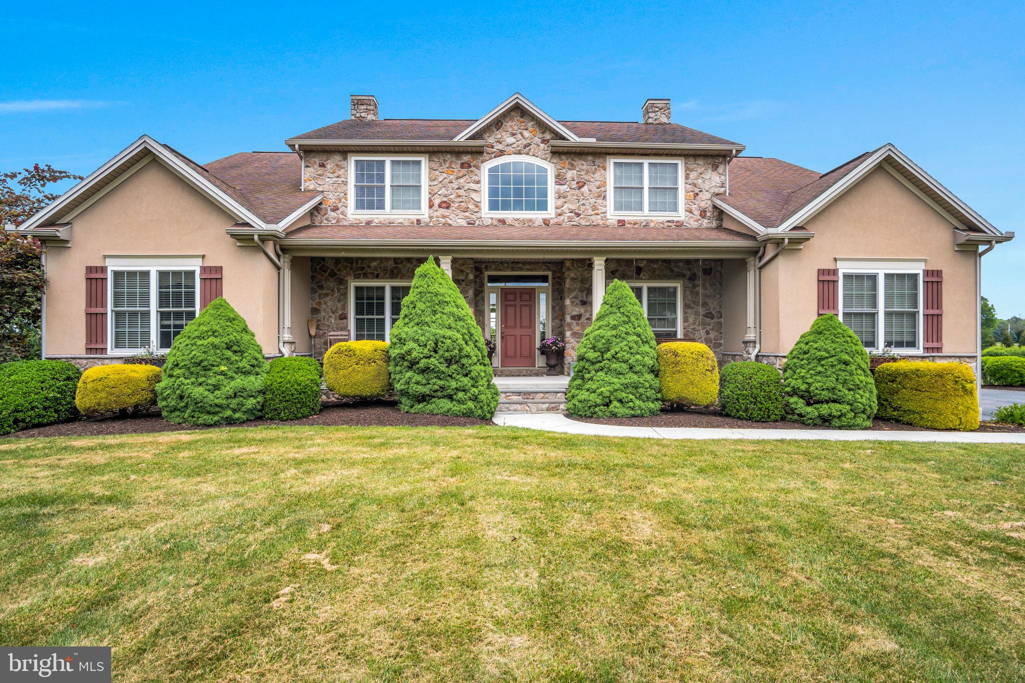 Situated in Ridge Estates community within Cumberland Valley School District, this beautifully maintained home sits on a peaceful 2.8-acre lot offering privacy and stunning views. A charming front porch welcomes you into the home, featuring a two-story foyer and hardwood flooring leading you throughout the spacious office and formal dining room. The kitchen boasts granite countertops, a breakfast nook, and access to the deck for easy outdoor dining and entertaining. The family room is the heart of the home with  hardwood flooring, tray ceiling, and a cozy fireplace. A mud room with laundry hookup and a half bath complete the main level.  Upstairs, the spacious primary suite features a walk-in closet and a newly remodeled bath with a soaking tub, walk-in shower, and double vanity. Three additional bedrooms, a full bath, and a Jack-and-Jill bath provide ample space. The finished walkout basement adds incredible flexibility with a family room, kitchen, gym, full bath, and second laundry hookup. Step outside to enjoy your morning coffee on the spacious deck or relaxing evenings on the patio. Perfect for entertaining or simply taking in the scenic views of this private 2.8-acre lot. The 3-car garage adds convenience. Do not miss your opportunity to call this home - book your tour today!