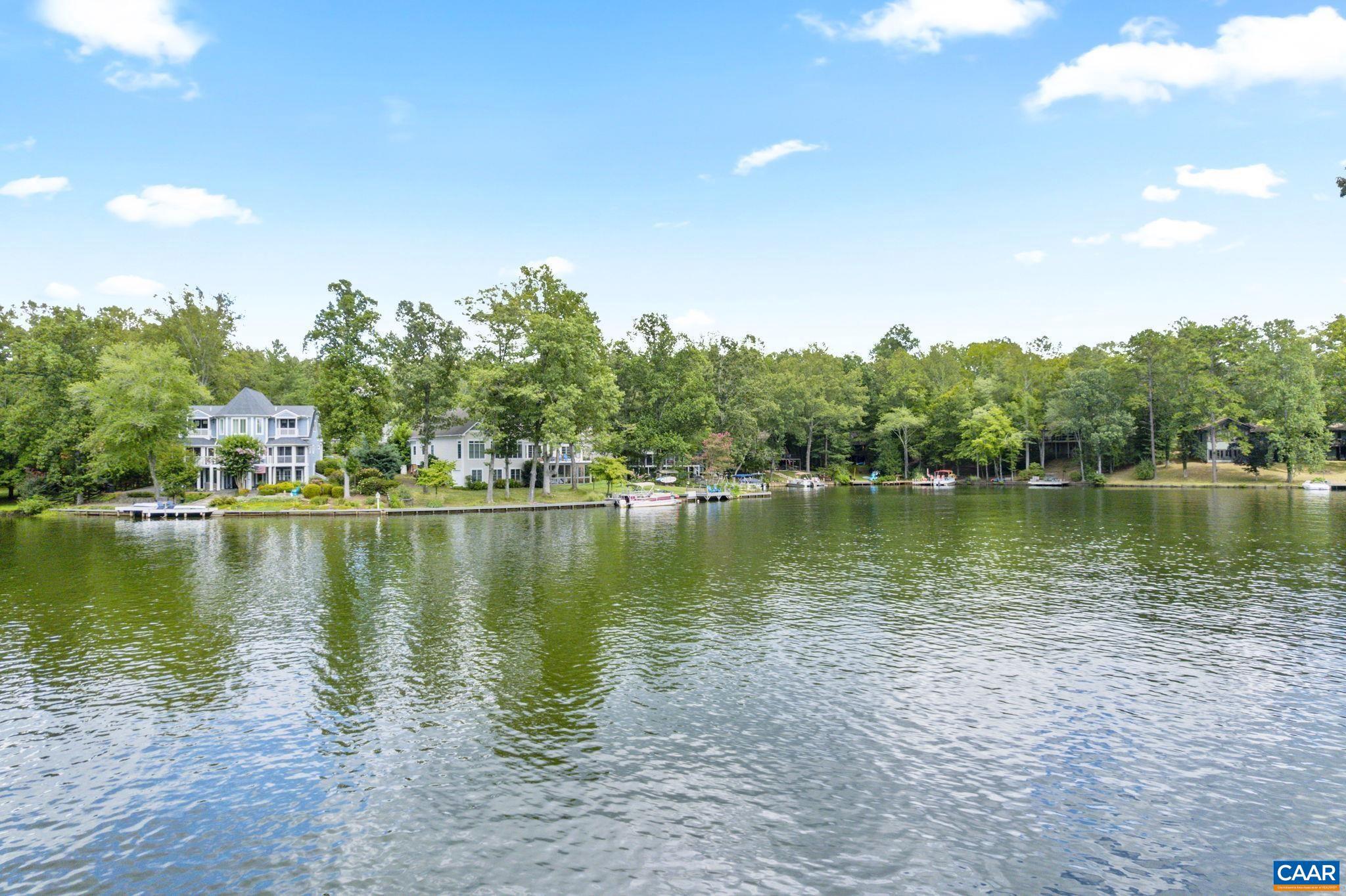 Tucked along the shores of Lake Monticello, this beautifully remodeled waterfront home on Lakeview Circle. This home offers the perfect blend of modern comfort and lakefront living. With breathtaking unobstructed water views and direct access from your backyard, you can enjoy fishing, swimming, boating and paddling anytime. This move in ready home has been completely transformed with a designers eye. Featuring 5 spacious bedrooms and 3 stunning custom tiled bathrooms. The kitchen showcases upgraded cabinetry, modern finishes, and expansive water views, flowing seamlessly into the open concept living space. Vaulted ceilings and expansive windows flood the home with sunlight, highlighting the rich hardwood floors and cozy fireplace. Step outside to an expansive deck and inviting sunroom-both perfectly positioned to capture the spectacular lake views, ideal for relaxing or entertaining. New mechanical systems and an extensive list of upgrades throughout, this home offers peace of mind and turnkey convenience, Located just around the corner from the clubhouse, tennis courts, pool and all the amenities. This property delivers an exceptional opportunity to enjoy an active lifestyle.  A Must see. More pics coming on Sunday,Cherry Cabinets,Granite Counter,Fireplace in Living Room