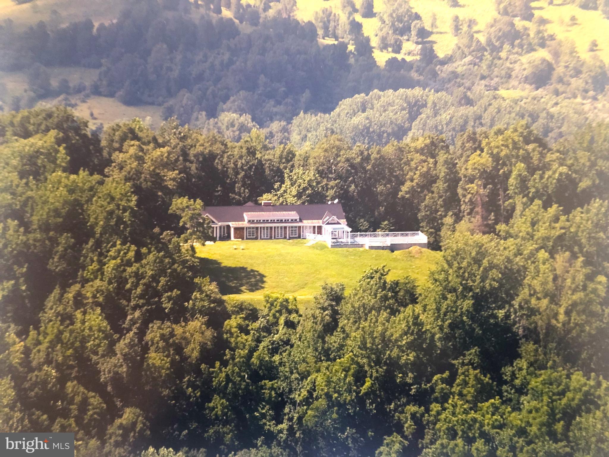 Liberty Hall is a commanding presence at the summit of Fogg Mountain, yet tucked away from the outside world.  This peaceful retreat has views in all directions, but is all but hidden from its neighbors.   The large reception rooms and comfortable private quarters mirror the dual nature of the property – both imposing and very private.  Suitable for a weekend escape, a full-time residence, or a luxury hunt box, this stately home epitomizes elegant country living.

The Main House was built as a true “hall” with large public rooms and private spaces along a long, mostly single story, framework.  The basement and upper story are not visually apparent upon first view.   Built in 1993, Liberty Hall was expanded approximately 10 years later to its current configuration with large dining room and pool terrace additions.  While the large rooms have an imposing grandeur, they are extremely comfortable gathering spaces for smaller intimate groups as well.  The exterior is weathered cedar shingles with a rubberized slate roofing shingles and bluestone coping and terraces off the kitchen and around the pool.

There is a one bedroom shingle cottage is located some distance away from the main house and is very private.  The cottage features a large stone fireplace and pine floors and small bath with shower.

The seventy-five acres at the top of Fogg Mountain are mostly wooded with a network of riding and walking trails leading down to a small pond at the bottom of the property.  Around the house is a gently sloping lawn that has been fenced for dogs.   Rock outcroppings add interest to the landscaping around the house.

Pool –  the heated pool is surrounded by a bluestone terrace and features a large pergola connecting the pool area to the house.
Barn – The barn is designed for two stalls with a small storage/tack room.  There is electricity and water.  A large overhang provides additional shelter for horses.
Paddocks –  There are two paddocks around the barn enclosed in three board fencing.  There is additional space below the house to expand paddock space if desired.