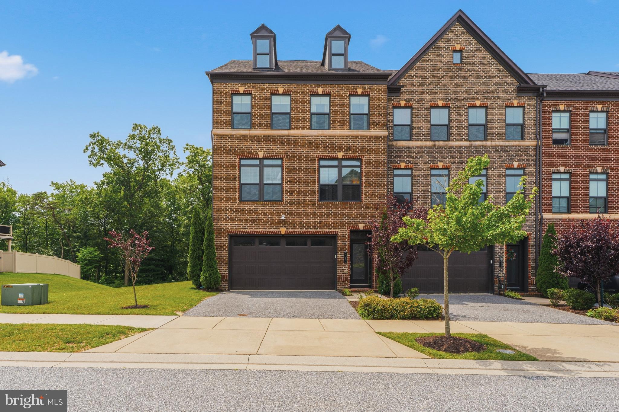 Welcome to Greenleigh, where modern luxury meets exceptional community living. Perfectly positioned on one of the most desirable lots in the neighborhood, this rarely available end-of-group townhome offers over 3,100 square feet of beautifully finished living space with serene wooded views that provide both privacy and a picturesque backdrop.

Step inside to discover an open, light-filled floor plan featuring gleaming hardwood floors throughout the kitchen, great room, dining area, and owner's suite. The gourmet kitchen is designed to impress with granite countertops, a large center island, stainless steel appliances, and abundant workspace—ideal for entertaining or everyday living. Custom built-ins add both style and functionality, while the great room opens to a maintenance-free deck where you can relax and enjoy the peaceful wooded setting.

The luxurious owner's suite serves as a private retreat, complete with hardwood flooring, a spacious walk-in closet, and a spa-inspired bath featuring dual shower heads. The upper level also includes a convenient laundry room, making daily living effortless.

The entry level offers exceptional flexibility with a spacious recreation room, a full bathroom, and walk-out access to the fully fenced backyard. The basement is perfect for guests, a home office, fitness space, or additional entertaining.

Additional highlights include an oversized two-car garage, three full bathrooms, and thoughtfully designed living spaces throughout.

Greenleigh's resort-style amenities elevate your lifestyle with a community pool, clubhouse, fitness center, dedicated yoga studio, scenic walking trails, and a dog park. Ideally located just minutes from Route 43, I-95, I-695, shopping, dining, and everyday conveniences, this home truly offers the perfect blend of luxury, comfort, and convenience.

Rare opportunities like this don't come along often. Schedule your private tour today and experience one of Greenleigh's premier homes for yourself.