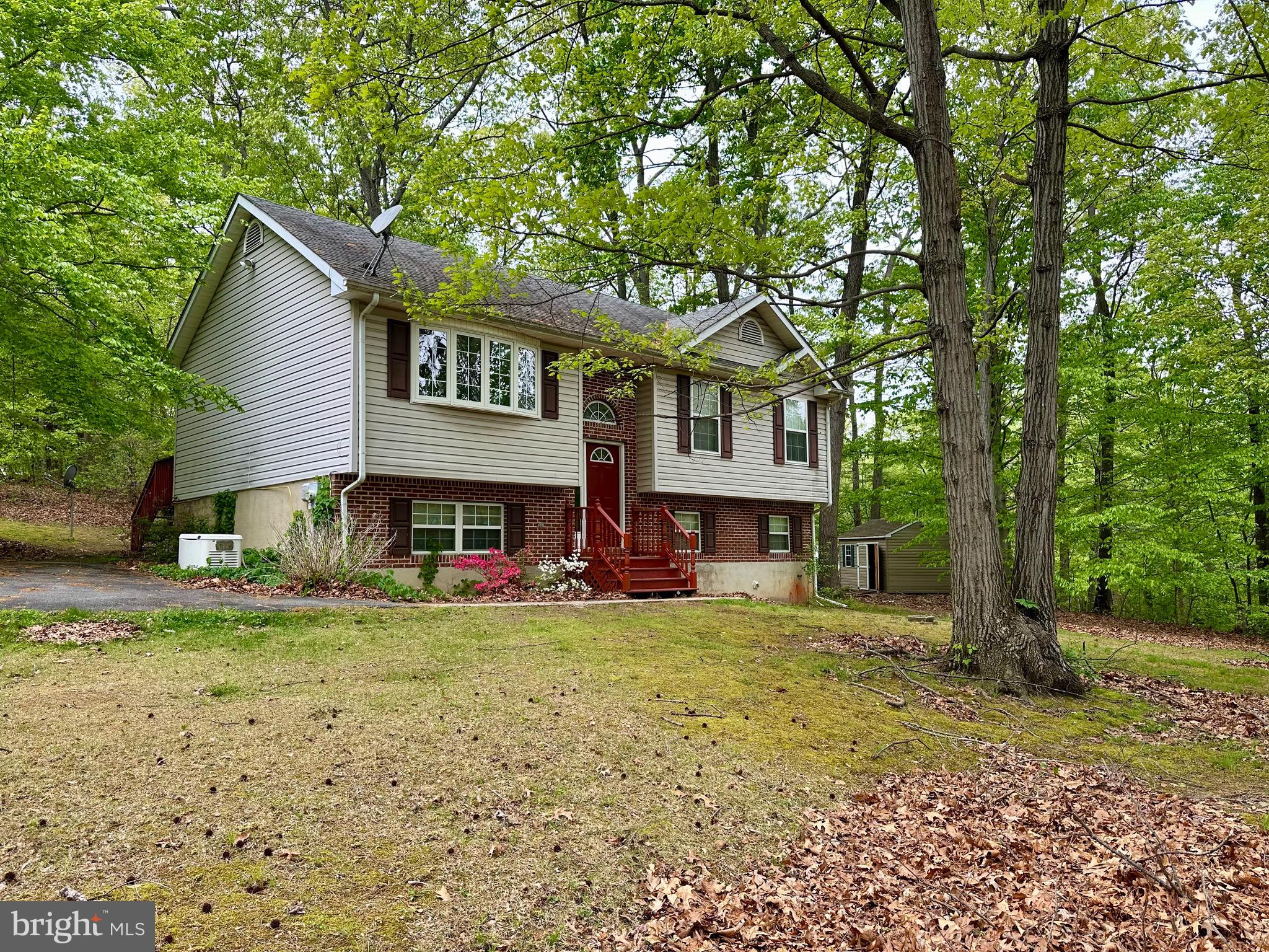 This home is waiting for your TLC, featuring 2 Bedrooms with the possibly to add a 3rd, 2 Full Baths, 3/4 Acre Lot, and Fully Finished Lower Level with Large Laundry/Storage Room.  Spacious living room with bay window. Eat-in Kitchen with room to add an island and includes access to rear deck. Primary Bedroom includes a full bath with tub/shower combination, ceiling fan and large closet. Down the hall you will find a 2nd full bath with tub/shower combination and 2nd bedroom includes ceiling fan and 5 x 8 Walk-in Closet. The lower level has an expansive family room with ceiling fan and under stair storage closet, 10 x18 laundry/storage room with exterior access, a possibly 3rd bedroom with full window, and utility room. Step outside to enjoy the private & wooded 3/4-acre lot with a rear wood deck, shed, and 4 car driveway. Updates includes: 2024 HVAC & whole house generator