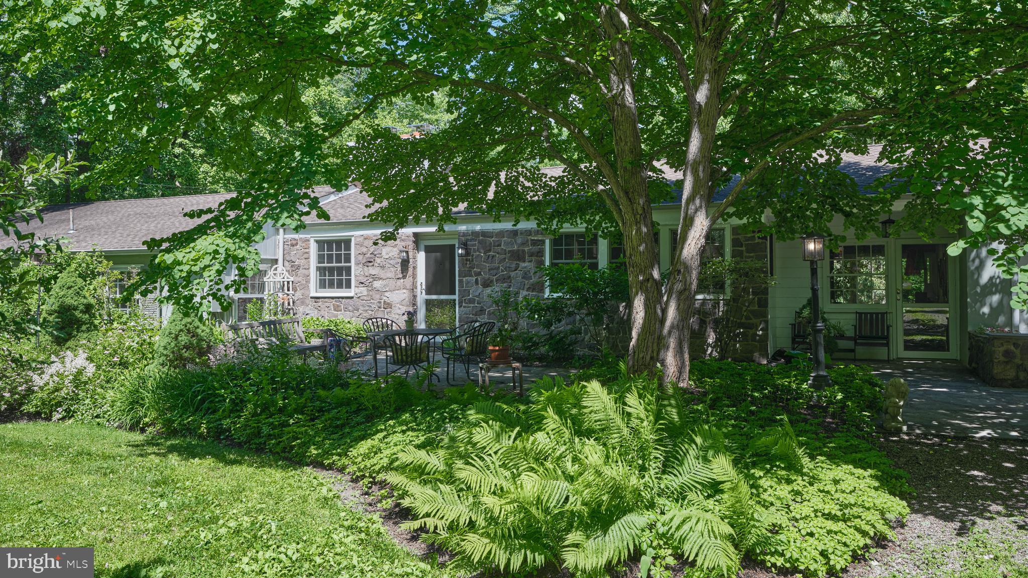 Tucked away on a quiet country lane just minutes from the heart of New Hope, this beautifully renovated residence offers a rare blend of privacy, comfort, and effortless living. Thoughtfully maintained and cherished by its owners for more than three decades, the home is surrounded by mature specimen trees, flowering gardens, and peaceful outdoor spaces designed to connect with nature.

Inside, an airy open-concept floor plan is anchored by a dramatic stone fireplace, cathedral ceilings, and sun-filled living spaces that flow seamlessly for everyday living and entertaining. The renovated kitchen opens to inviting gathering areas, while a second fireplace creates a warm and intimate den. Three bedrooms, two updated baths, and a dedicated office provide flexibility for today's lifestyle.

Outdoor living is equally compelling. The bluestone "Breakfast Terrace," embraced by colorful gardens, has long been a favorite spot for morning coffee, birdsong, and quiet reflection. A private deck off the primary suite offers tranquil views of the meadow-like grounds, while a second deck adjoining the breezeway and wet bar creates an ideal setting for entertaining. Summer evenings bring the enchanting spectacle of fireflies dancing through the gardens and trees, a tradition treasured by the current owner.

A fenced vegetable garden adds to the property's charm and connection to the land. Just moments away, enjoy the restaurants, galleries, boutiques, theater, and riverside atmosphere that have made New Hope one of the region's most sought-after destinations. Explore miles of scenic towpath, paddle the Delaware River, or enjoy exceptional birdwatching, including sightings of majestic bald eagles.

Offering a sense of retreat without sacrificing convenience, this is a home of warmth, character, and enduring appeal—ready to be loved for generations to come.