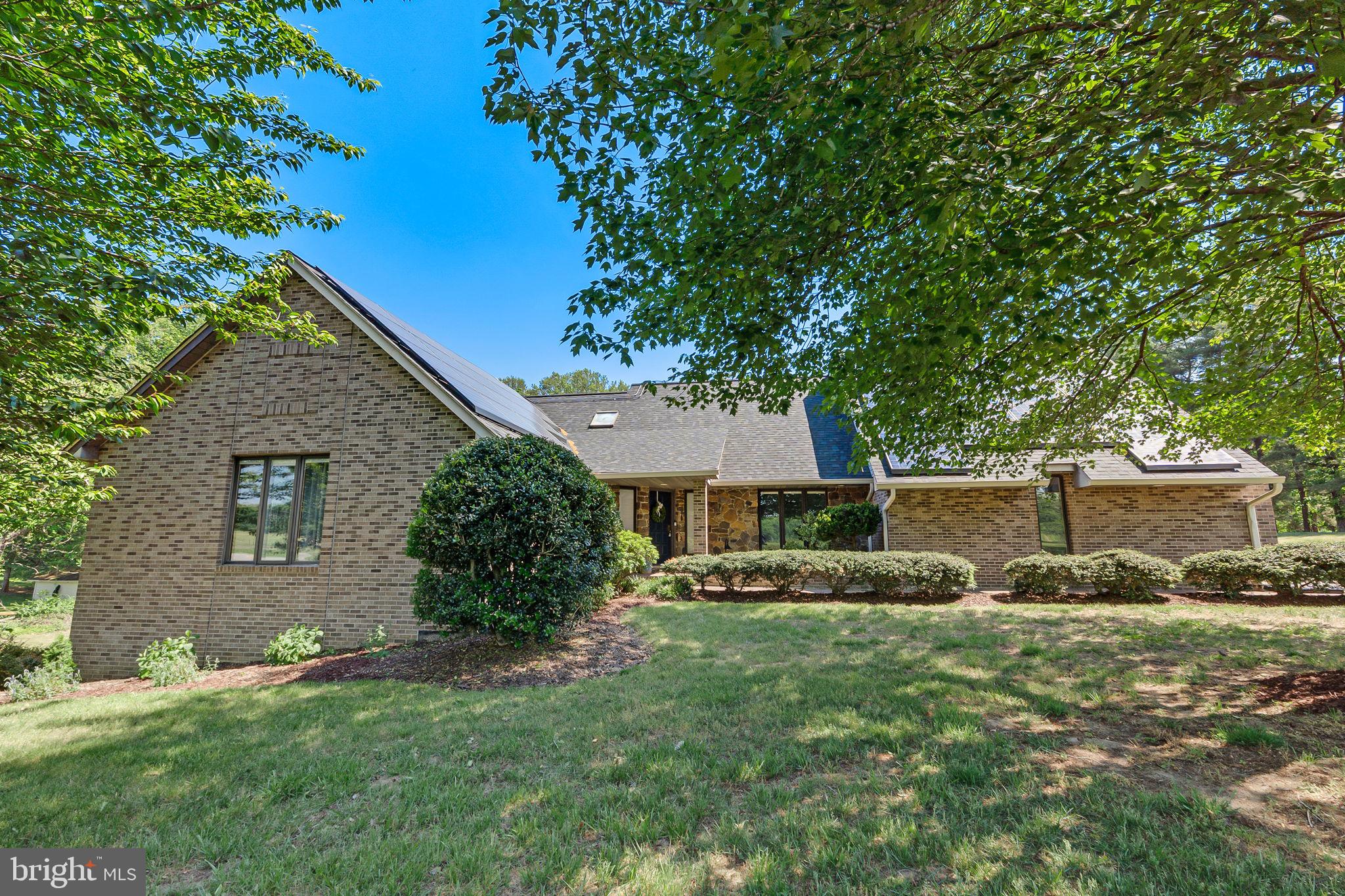 Welcome to one of Huntingtown's most exceptional properties—a truly one-of-a-kind all-brick estate situated on 3 beautiful, usable acres in one of Calvert County's most sought-after locations. Offering timeless craftsmanship, modern updates, and endless possibilities, this remarkable home is the perfect blend of luxury, comfort, and functionality—all with no HOA.

Step inside and be greeted by gleaming, newly refinished hardwood floors, soaring vaulted ceilings, skylights, and oversized casement windows that flood the home with natural light. The spacious main-level primary suite is a private retreat featuring a separate sitting room, walk-in closet, and spa-inspired bath with a soaking tub and separate shower.

The heart of the home is the impressive great room, showcasing a stunning floor-to-ceiling brick wood-burning fireplace, a dramatic wall of windows, and a wet bar—creating the perfect gathering space for entertaining family and friends.

The beautifully renovated kitchen offers stainless steel appliances, abundant cabinetry, and easy access to the charming brick patio, making outdoor dining and grilling effortless.

Upstairs, you'll find three generously sized bedrooms, two full bathrooms, and a versatile loft overlooking the great room—ideal for a reading nook, home office, or play area.

The fully finished walk-out lower level expands your living options with an incredible entertainment area featuring a full wraparound bar, dishwasher, beverage cooler, and commercial-grade nugget ice maker—an entertainer's dream. The lower level also includes two additional bedrooms, a full bathroom, and a spacious workshop. With private access, this space offers excellent potential for multigenerational living, guest quarters, or even a separate apartment to help offset your mortgage.

Outside, the massive detached barn/garage is a rare find. Complete with electric service and a half bath, it offers room for 4-6 vehicles, equipment, hobbies, or business use. With its expansive loft, the structure could easily be converted into a traditional barn for animals, while still providing ample storage for hay, equipment, or recreational vehicles.

Additional updates and features include:
• Newer roof
• New water heater
• Both HVAC systems replaced within the last two years
• Water softener installed in 2023
• Both dishwashers approximately one year old
• Newer washer and dryer
• Radon mitigation system installed

This extraordinary property combines privacy, versatility, and convenience in one of Huntingtown's most desirable settings. Whether you're looking for room to grow, space for hobbies and animals, multigenerational living, or simply a stunning home with exceptional amenities, this property truly offers it all.