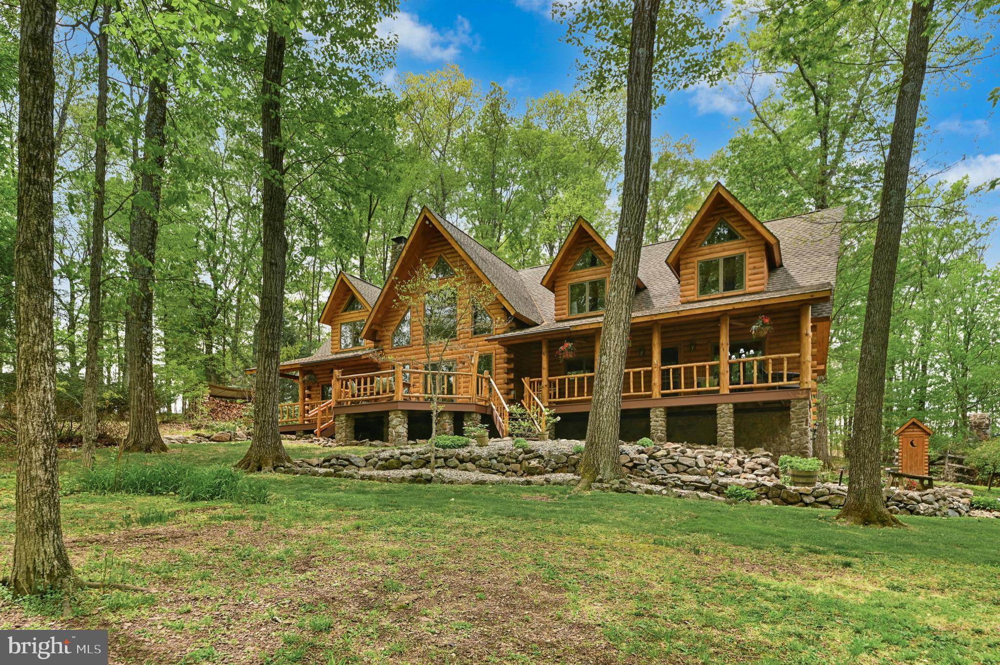 Rarely does a home so perfectly complement its setting as this masterfully crafted modern log estate. At the end of a winding driveway off a quiet country road in scenic Upper Bucks County, the property unfolds across five acres enveloped by majestic forest.
     Soaring ceilings, rich wood finishes, and walls of oversized windows fill the interiors with natural light. At the heart of the home, the spectacular two-story great room is anchored by a fieldstone fireplace that rises to the second floor, offering warmth and drama. The floor plan offers exceptional versatility, featuring three first-floor bedrooms or office spaces accompanied by two generously appointed full baths. Upstairs, a spacious recreation/game room is joined by three additional bedrooms and two baths, including a luxurious primary suite with a sitting room/library retreat, spa-inspired bath with heated floors, clawfoot soaking tub, and oversized shower.
     The finished lower level features a wet bar, family room with a second stone fireplace, fitness room, full bath with stone shower and garage. Outside, a resort-inspired entertaining complex includes a heated in-ground pool with stone waterfall and fireplace, and cabana. An oversized three-car garage offers ample space for hobbies, collections, and recreational equipment.
    A private retreat equally suited as a full-time residence or luxurious weekend escape.