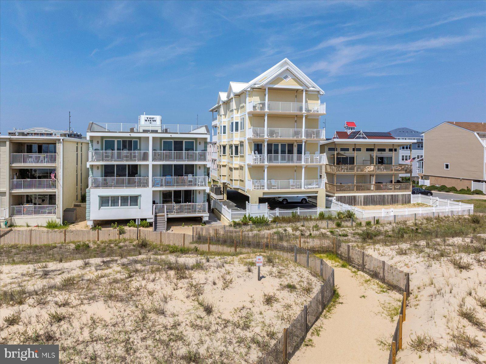 Unparalleled Luxury on the Oceanfront! Welcome to Sunrise Beach, a premier oceanfront destination offering the epitome of coastal elegance. This exceptional 3-bedroom, 3-bath condominium occupies the entire second floor of an exclusive 4-unit building, where privacy, security, and spectacular views define the experience. From the moment you arrive, a secure private elevator opens directly into your foyer. Step inside and be captivated by over 35 feet of unobstructed glass showcasing breathtaking panoramic views of the ocean. Floor-to-ceiling windows line the entire oceanfront of the residence, immersing you in the sights and sounds of the Atlantic, while additional north and south-facing windows offer sweeping vistas up and down the beach. The oceanfront great room is one of the largest in Ocean City, featuring a cozy gas fireplace, elegant sitting area, and seamless flow into the dining and kitchen spaces—perfect for both everyday living and stylish entertaining. The gourmet kitchen is a chef’s dream, appointed with Wolf and Sub-Zero appliances, including two refrigerator drawers,  granite countertops, custom cabinetry, soft-close drawers, tile backsplash, tray ceiling, pantry, and counter seating, all illuminated by a sunny window over the sink. The spacious primary suite offers a peaceful retreat with ocean views, a large walk-in closet, and a spa-style bath with Jacuzzi tub, walk-in shower, and custom ceramic tile. Each guest bedroom has its own private en-suite bath, with the third bath doubling as a convenient powder room for visitors. With over 2,000 square feet of thoughtfully designed living space, this residence is filled with upscale details, including electric storm shutters and blinds, recessed lighting, crown molding, wainscoting, and large-format ceramic tile. A separate laundry room with sink, storage cabinets, and full-size washer and dryer adds everyday convenience. Step onto your expansive oceanfront balcony and enjoy coffee at sunrise or simply relax and take in the ever-changing sights and sounds of the ocean and beach. Assigned covered parking provides ease of access, and the adjacent walkway allows you to step directly onto the sand. Sunrise Beach is more than a home—it’s a rare coastal sanctuary that must be seen to be believed.  Professionally managed with a recently replaced roof, entire building plus balconies recently painted, and an up to date reserve study make this condominium even more desirable. Whether as a luxurious primary residence or an elite second home, this 2nd floor unit offers a one-of-a-kind lifestyle in one of Ocean City’s most exclusive settings.