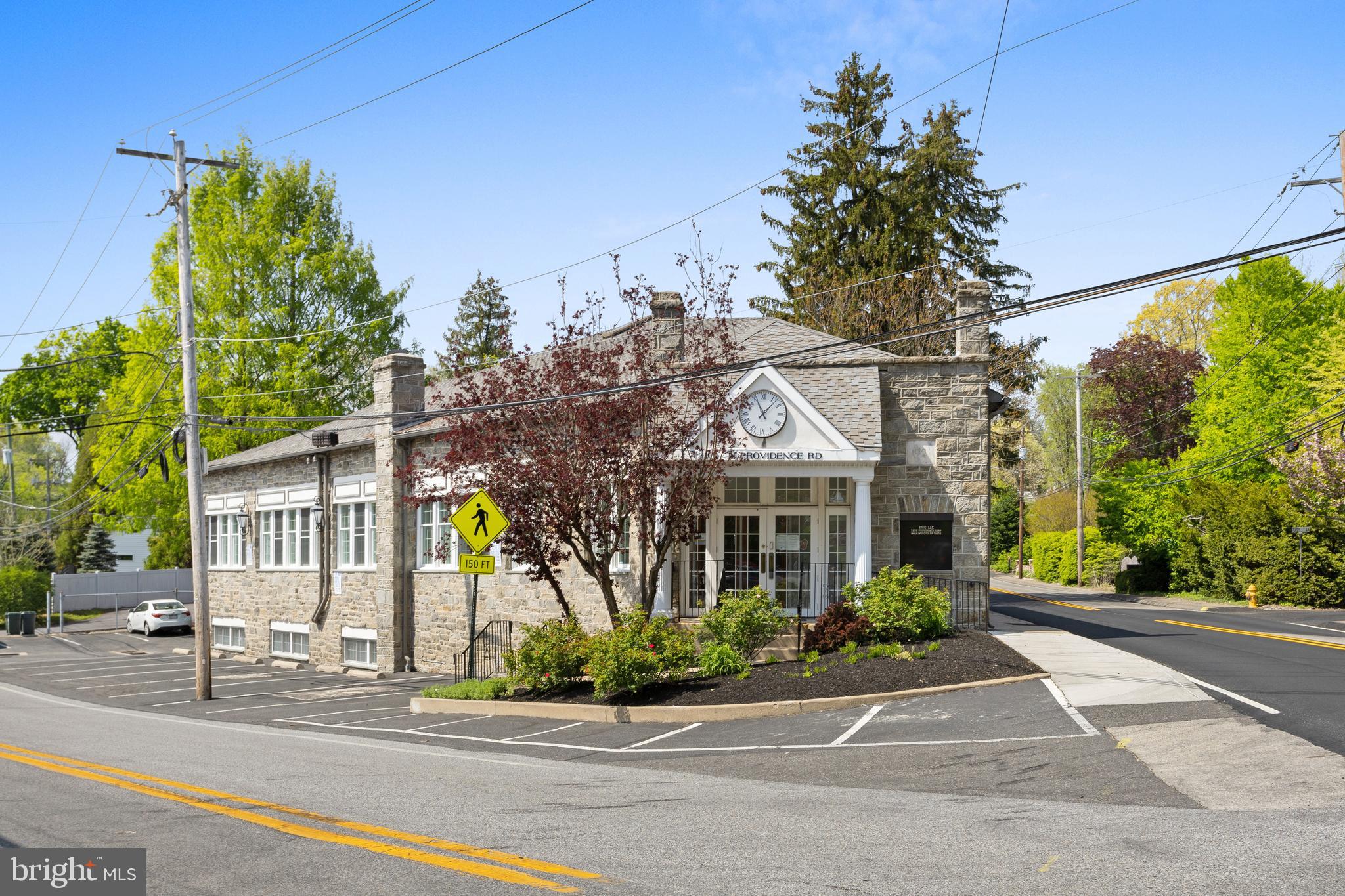 Own an iconic slice of property in Wallingford! Close to Media. This 1921 stone and steel building has exceptional visibility and two-street frontage, making for a great investment or owner-occupied office space. The building boasts abundant natural light, on-site parking for 15 with a small outside eating area, and mature trees. Conveniently located near Media Borough and the Blue Route, next to a Septa bus 118 stop and near Septa R-3 Commuter Rail Station in Wallingford. This approximately 6100 square foot office building features 10 offices on the ground floor, four cubicles, reception area, baths, and coffee station. An 11th office overlooks the main floor. The lower level includes a large conference room, gym, 2 locker rooms, kitchenette, laboratory and storage.  New HVAC in 2023 and French drain installed recently. Currently under lease to an engineering firm which will stay until at least Dec 2024, with a lease termination date of June 2025. Come make this unique and useful space yours!