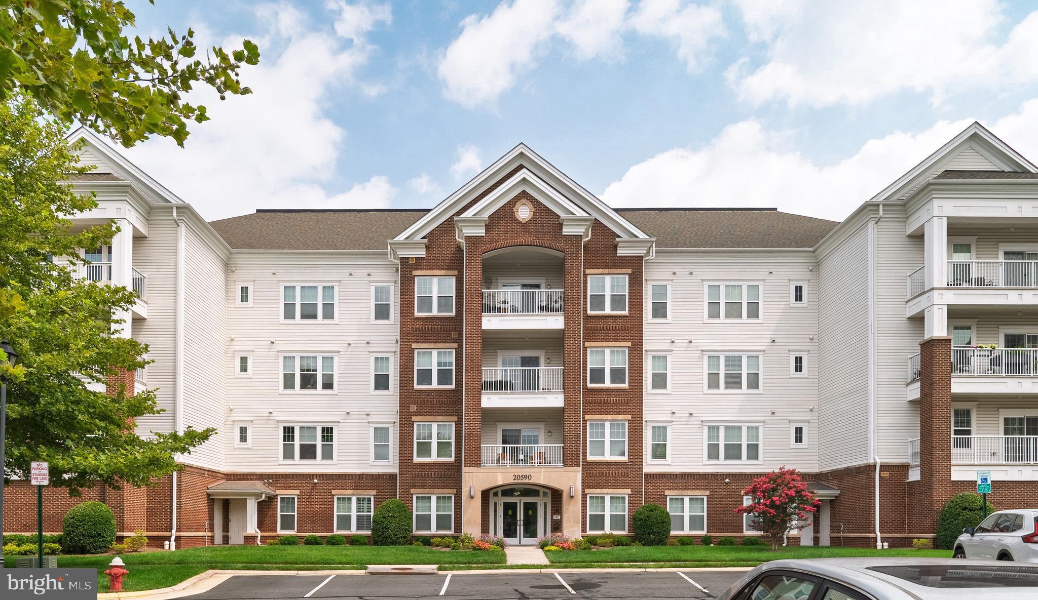 $10,000 Price reduction - motivated seller! Open house Sunday 12-2pm July 26th.  Fantastic opportunity to own in Potomac Green - Loudoun County's premiere active adult community! This beautiful Beaumont model condo offers 2 spacious bedroom 2 full bathroom over 1347 square feet of living space - PLUS there's a charming balcony backing to private woods with a custom made patio screen $3000 value, covered parking spot, AND extra storage unit! Gourmet kitchen features wood flooring, granite countertops, maple cabinets with under cabinet lighting, and stainless steel appliances (gas cooking!). Grab a quick bite at the breakfast bar or host meals in the formal dining room, with elegant crown and chair rail molding. Large living area has crown molding, and a slider door out to the balcony. Expansive primary bedroom, which offers custom walk-in closet, BONUS additional closet, and a large en-suite bathroom with double vanity, ceramic tile floor, and standalone shower with glass door and built-in seat. Spacious second bedroom would also make for an excellent home office, and the full guest bathroom has a tile floor and shower/tub combo. Recent updates to include entire condo freshly painted, new water heater, custom closet shelfs. The vibrant Potomac Green community wins awards for a reason - standout amenities, an array of social opportunities, and an ideal location. The gated neighborhood has a remodeled 26,000 square foot clubhouse, indoor and outdoor pools, tennis and pickleball courts, fitness center and indoor track, miles of trails, and even garden plots! Residents can participate in a dazzling variety of clubs, groups and activities - there truly is something for everyone. Enviable proximity to One Loudoun, the Loudoun County Senior Center, Inova Loudoun Hospital, as well as major routes of transportation. Pride of ownership!!