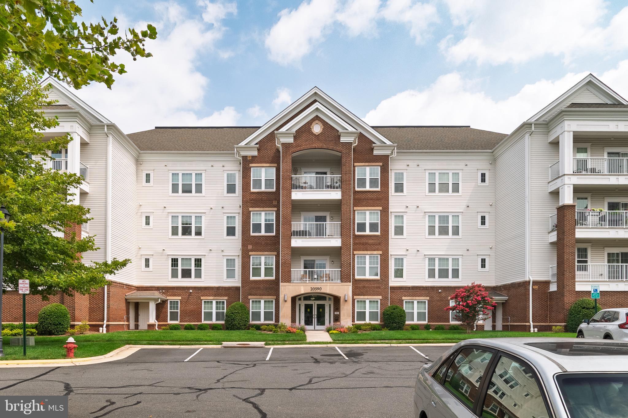 Fantastic opportunity to own in Potomac Green - Loudoun County's premiere active adult community! This beautiful Beaumont model condo offers 2 spacious bedroom 2 full bathroom over 1347 square feet of living space - PLUS there's a charming balcony backing to private woods with a custom made patio screen $3000 value, covered parking spot, AND extra storage unit! Gourmet kitchen features wood flooring, granite countertops, maple cabinets with under cabinet lighting, and stainless steel appliances (gas cooking!). Grab a quick bite at the breakfast bar or host meals in the formal dining room, with elegant crown and chair rail molding. Large living area has crown molding, and a slider door out to the balcony. Expansive primary bedroom, which offers custom walk-in closet, BONUS additional closet, and a large en-suite bathroom with double vanity, ceramic tile floor, and standalone shower with glass door and built-in seat. Spacious second bedroom would also make for an excellent home office, and the full guest bathroom has a tile floor and shower/tub combo. Recent updates to include entire condo freshly painted, new water heater, custom closet shelfs. The vibrant Potomac Green community wins awards for a reason - standout amenities, an array of social opportunities, and an ideal location. The gated neighborhood has a remodeled 26,000 square foot clubhouse, indoor and outdoor pools, tennis and pickleball courts, fitness center and indoor track, miles of trails, and even garden plots! Residents can participate in a dazzling variety of clubs, groups and activities - there truly is something for everyone. Enviable proximity to One Loudoun, the Loudoun County Senior Center, Inova Loudoun Hospital, as well as major routes of transportation. Pride of ownership!!