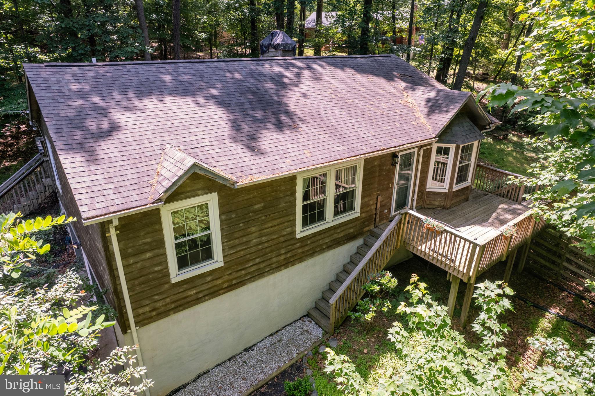 “Shannondale Ranch” - Nestled on an oversized nearly 0.5-acre lot in the desirable Shannondale community of Harpers Ferry, this 3-bedroom, 2-bath raised ranch offers over 1,400 square feet of main-level living space and endless potential for the right buyer. Built in 1992 and surrounded by peaceful forest views, this home combines a functional open-concept layout with opportunities to add your own personal touch and value.

Inside, vaulted ceilings create an airy and inviting atmosphere throughout the main living areas. The improved kitchen features custom cabinetry, upgraded countertops, and stainless steel appliances, flowing seamlessly into the dining and living spaces for easy everyday living and entertaining. Just off the kitchen, a bright sunroom fills the home with natural light while offering tranquil views of the surrounding nature.

The finished basement expands the living space with a cozy den featuring a fireplace, laundry area, additional finished bonus space perfect for hobbies or a home office, and convenient access to the attached garage.

Located in a highly convenient commuter location near the historic charm, shops, restaurants, and outdoor recreation of Harpers Ferry National Historical Park, this property is ideal for buyers seeking both accessibility and a peaceful mountain-community setting.

This sale is part of a family estate, and the current owners have never occupied the property, therefore they are unable to speak to the overall condition or maintenance history of the home. Priced to sell, this property presents a fantastic opportunity for someone ready to invest a little sweat equity and make it their own.