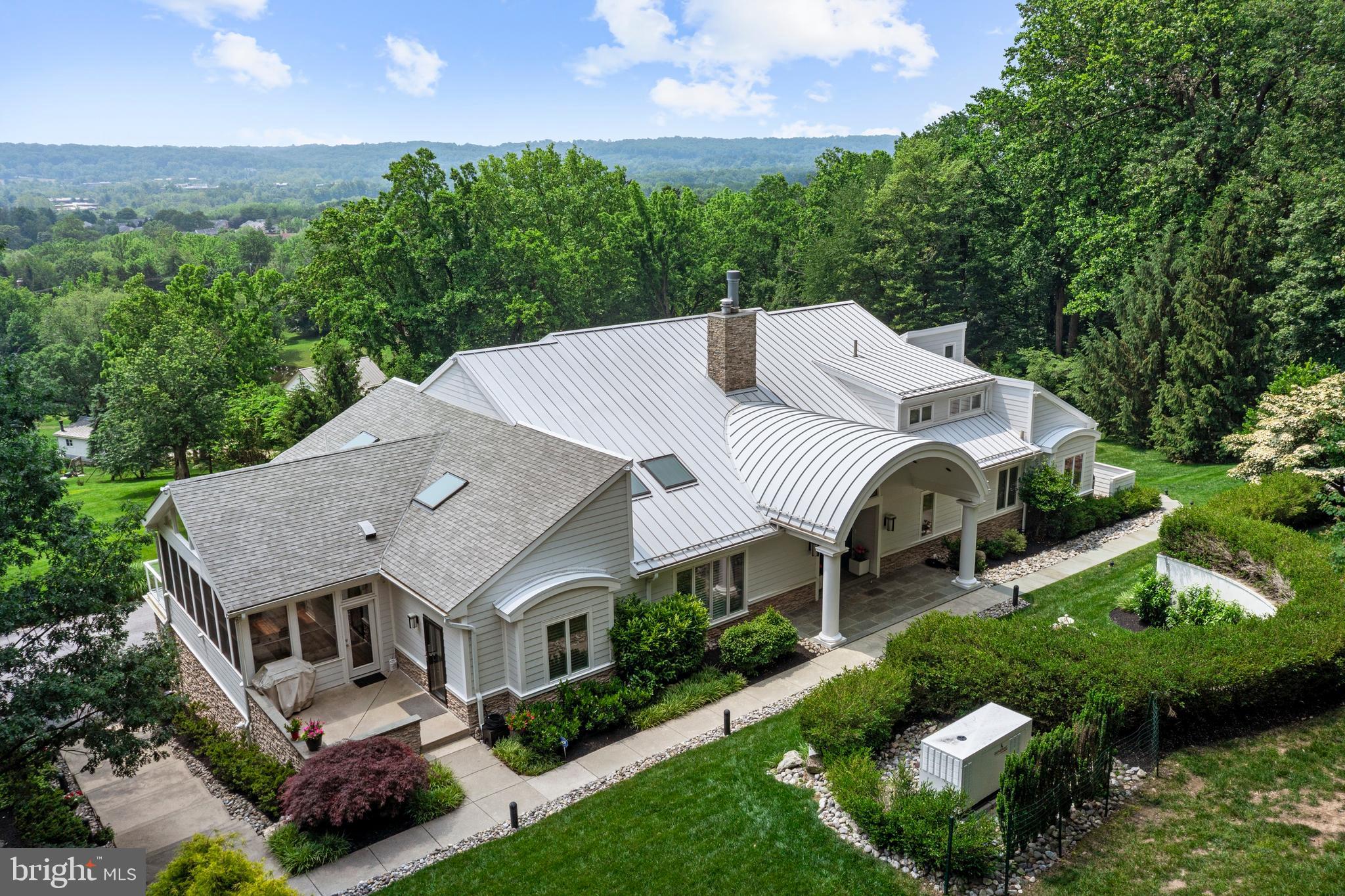 Nestled atop the serene and picturesque landscape of Valley Forge Mountain, this architectural masterpiece awaits. Occupying five bucolic,private acres, this rare gem offers an unparalleled living experience within the esteemed Tredyffrin/Easttown School District. With 6,635 square feet of completely renovated, sensational living space, this residence is a testament to exquisite craftsmanship and sophisticated design.
Upon entry, a grand foyer welcomes you into a breathtaking great room, distinguished by its soaring 22-foot ceilings, custom Marble floors, and an oversized  marble fireplace. An abundance of windows throughout, and French patio doors bathe the space in spectacular natural light, offering panoramic vistas, stunning views of the valley and the surrounding natural beauty. Step through these doors onto a gorgeous deck that overlooks a spectacular backyard oasis, a perfect setting for tranquil relaxation or grand-scale entertaining.

The art of entertaining is perfected in the oversized, beautiful dining room, which flows seamlessly into the heart of the home: the stunning gourmet kitchen. Prepare to be captivated by this extraordinary, sun-drenched culinary haven. Featuring high ceilings with two skylights and two oversized Carrera marble islands, this state-of-the-art kitchen is a chef's dream. Top-of-the-line appliances include a 6-burner Wolf dual range with griddle, three Wolf ovens, a warming drawer, a built-in Sub-Zero refrigerator, an additional under-counter Sub-Zero refrigerator and freezer, a wine refrigerator and icemaker in the bar area, and a walk-in pantry.

Adjacent to the kitchen, an enclosed sun porch, or three-season room, offers a tranquil retreat with expansive views through its oversized windows. For more casual gatherings, a sensational family/theatre room off the kitchen boasts two-level seating and custom built-ins.

The magnificent first-floor primary suite is a sanctuary of its own, featuring high ceilings, an enormous walk-in closet, and an additional large sitting room with a gorgeous private deck. The convenience of a spacious laundry room with custom built-in cabinetry is also found on this level. The en-suite master bathroom is a study in luxury, with stunning Travertine  floors, an oversized double shower , a wonderful Jacuzzi tub, a gorgeous double sink vanity, custom cabinetry, linen closets, ample storage, and his-and-hers water closets.

The second floor reveals a charming balcony overlook and a south-facing deck that spans the entire length of the floor, offering truly panoramic views. This level hosts a second magnificent master suite, complete with a large walk-in closet and a gorgeous master bath. An additional beautiful office or bedroom with deck access completes this floor.

The beautifully designed lower level extends the living space with three additional large bedrooms and a new, gorgeous bathroom. This level also features a separate laundry room, a workout room, wine storage, and a sauna. An enormous family room with a built-in wet bar and custom bookcases provides another fantastic entertaining space. From here, an additional oversized office with two sets of French doors opens out to the beautiful backyard.
This exceptional property also includes a six-plus car garage, as well as an additional storage garage for lawn maintenance equipment. With its stunning landscapes and flourishing gardens, this home is truly a sensational place to call home and a perfect venue for creating lasting memories.