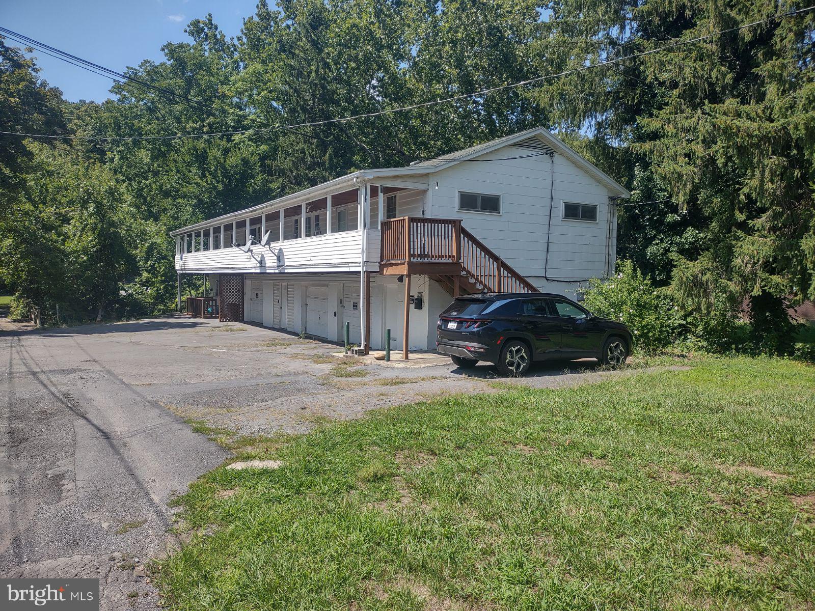 INVESTMENT: great property for some extra income. This building has 3 units generating $2,100.00 per month revenue. Two of the apartments have 3 bedrooms 1 bathroom and a Living/Dining combo. Covered front porch & each have a garage space. Laundry area is downstairs. The 3rd unit is an efficiency apart. Currently rooms are full time rentals but could also be short term rentals for visiting Historic Berkeley Springs/Bath. This property is located in the town limits which makes it convenient for walking the town.