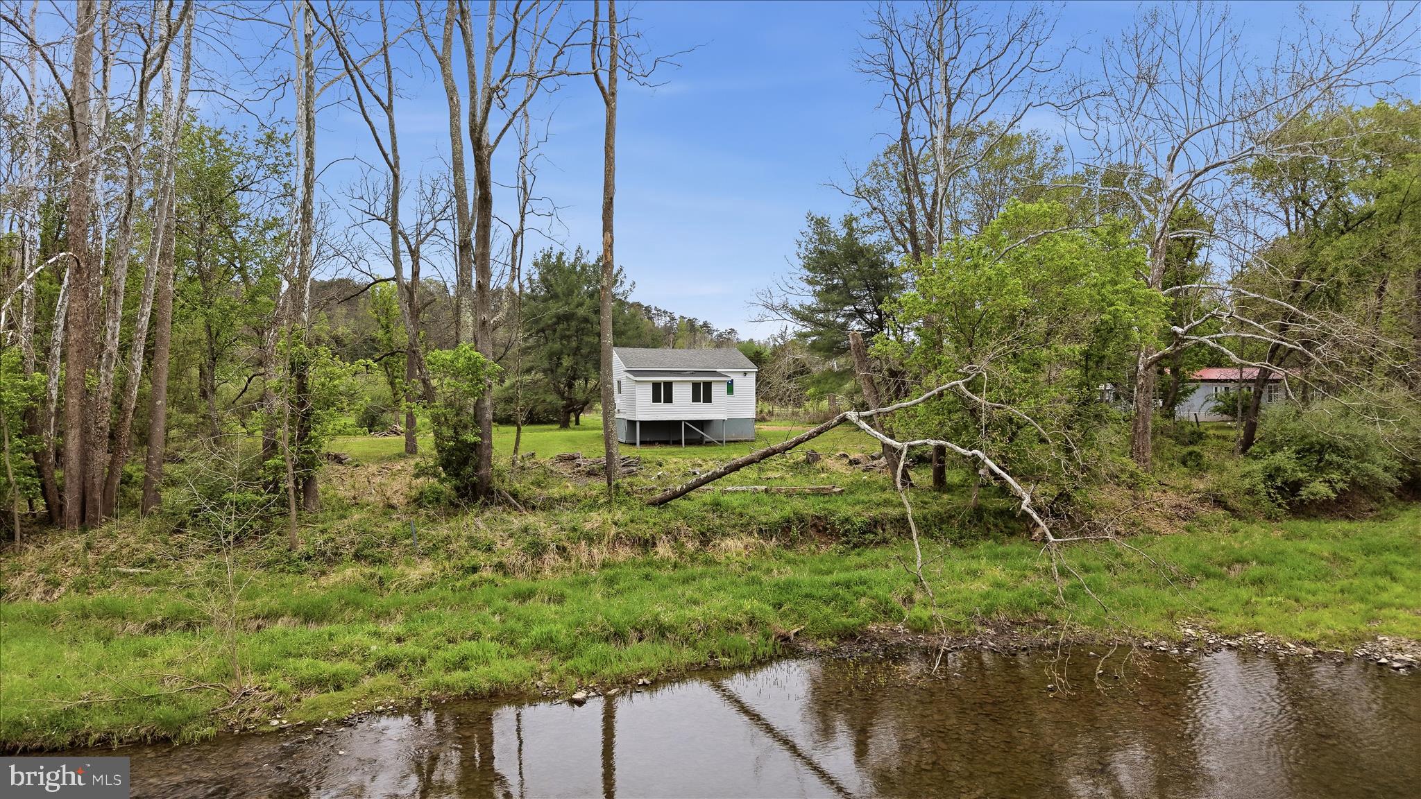 NEW PRICE ON THREE RIVERFRONT ACRES!  Get away from it all only 45 minutes from Winchester and 15 minutes from Capon Bridge!  Larger than it looks, this home is situated on 3 flat acres and offers 138 feet of North River frontage—perfect for kayaking, splashing around, and enjoying the outdoors.  Gorgeous wooden doors and trim throughout the home, including a beautiful ceiling in the primary bedroom. Watch the river flow by from the secondary bedroom windows! Recent updates include new lvp flooring, well pump, hot water heater, and water treatment system.  Roof was replaced in 2023.  HOA for road maintenance only.  Roads are paved until 1 mile from the property. Square footage on the tax record is incorrect.  Property is located in the 100-year flood plain, current over pays just over $100/month for flood insurance. Don't let that scare you away, the home was designed for where it sits!  This would be perfect for a full time residence or a weekend getaway!