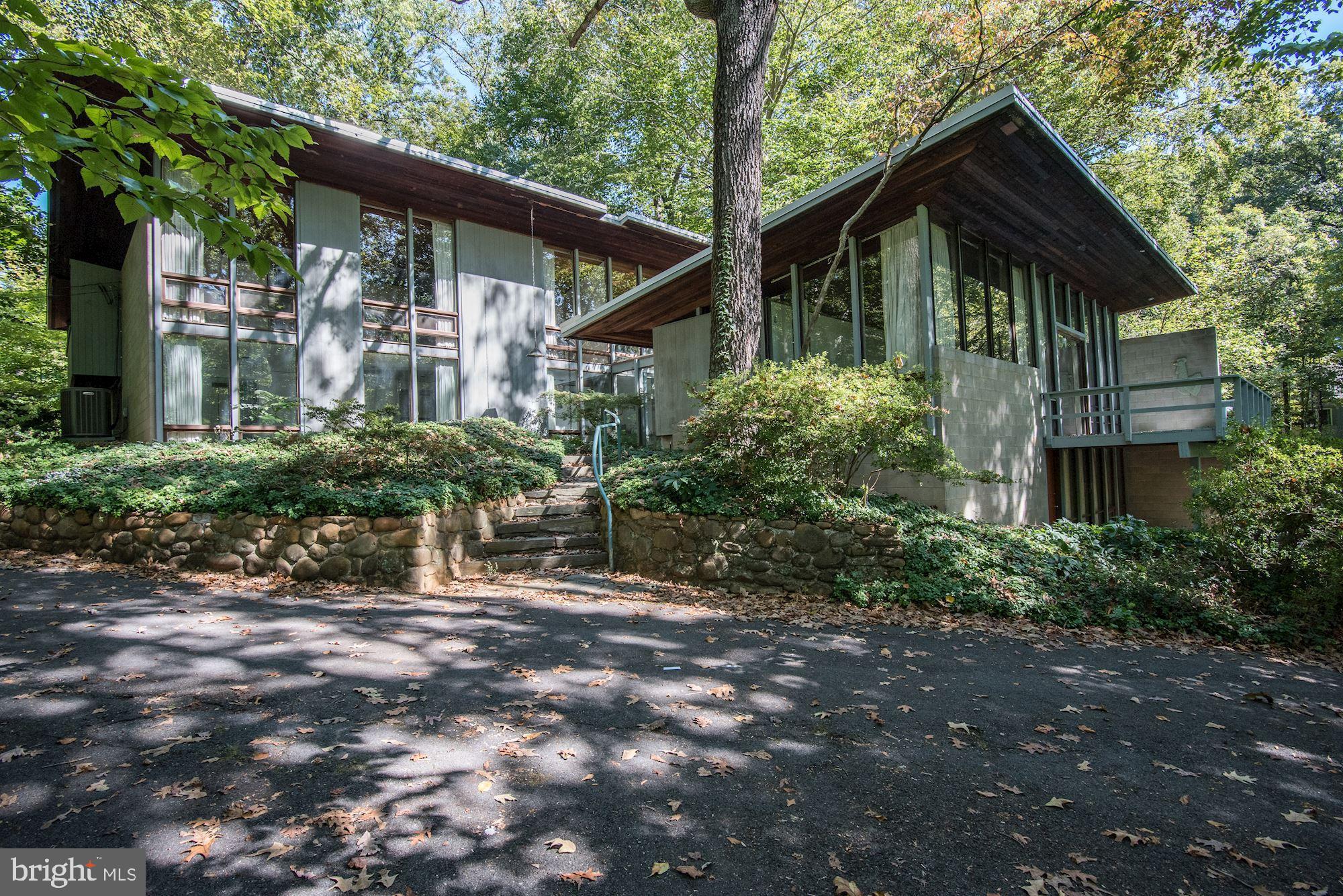 This one-of-a-kind contemporary sited high on a wooded lot is now available for sale.  A treehouse effect is created by massive windows in every room, overlooking peaceful views in all directions.  The main level provides an atrium entrance hall, sunken great room with fireplace, master suite with bath, dining room, family room, powder room, floating staircase, and access to a glass roofed breakfast room.  The upper level has a second master suite, two guest bedrooms, a built-in desk, and a full bath.  The lower level provides a nice in-law/au-pair with a private entrance family room, bedroom, full bath, and storage.