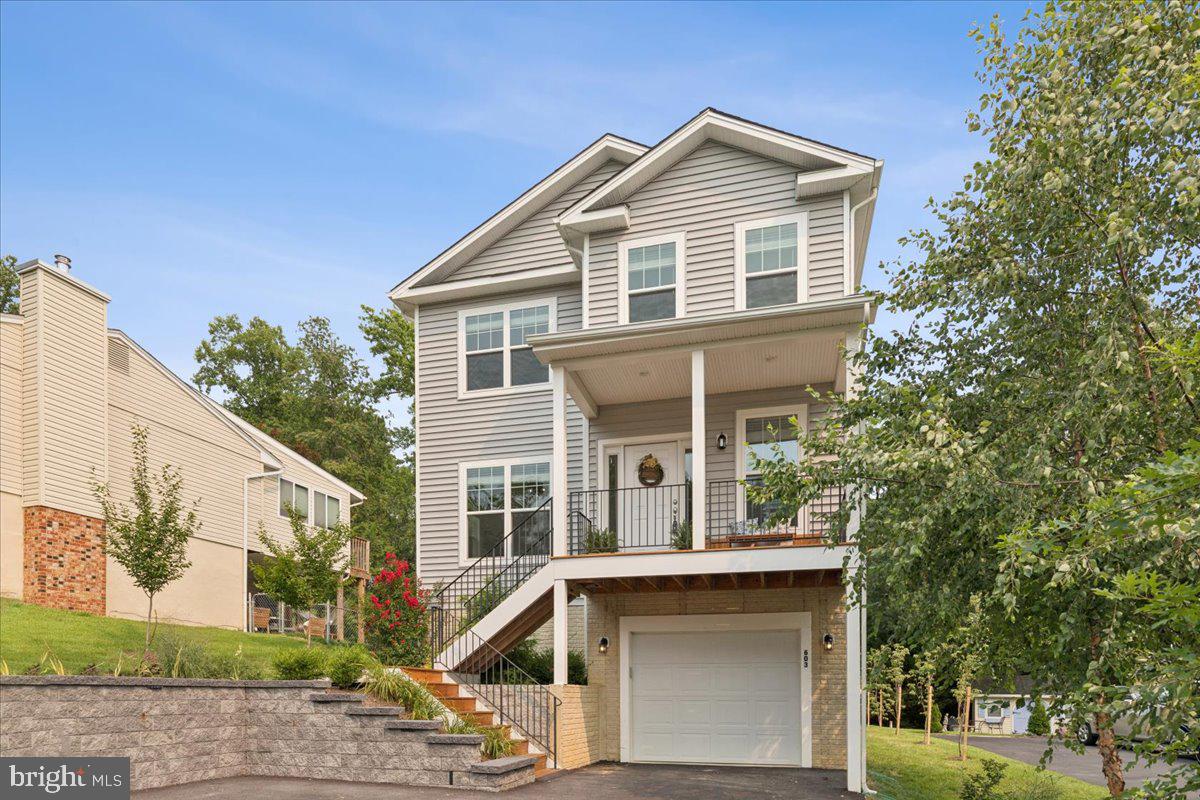 Welcome to 603 Overhill Dr, a beautifully maintained 4 bedroom, 2.5 bath showstopper offering 2,684 finished square feet of living space. Built in 2022, this modern home delivers all the benefits of new construction—without any of the hassle! Nestled in the highly sought‑after, water‑privileged community of Holly Hill Harbor, residents enjoy access to a community park, boat ramp, and pier. Step inside to a bright, airy foyer that immediately sets an inviting tone. Just off the entry, a dedicated home office with glass French doors and abundant natural light creates an ideal space for remote work or creative pursuits. The main level features an open‑concept layout with 9ft ceilings, wide‑plank engineered hardwoods, and seamless flow. The chef’s kitchen is the heart of the home, showcasing crisp white cabinetry, gleaming quartz countertops, stainless steel appliances, and an oversized island perfect for entertaining. French doors open to a peaceful back deck overlooking a private wooded backdrop, while a cozy fireplace anchors the living room. Upstairs, the primary suite offers a spacious walk‑in closet and a spa‑inspired en suite bath with dual sinks, a marble‑top vanity, and a glass walk‑in shower. Three additional generously sized bedrooms and a full bath complete the upper level. The finished walkout basement provides flexible space for a secondary living room, playroom, fitness area, or whatever suits your lifestyle. A stylish stone retaining wall with recessed lighting, extra wide asphalt driveway, and attached garage offers convenient parking plus extra storage or workout space. Brand new whole-house water filtration system with UV purification, upgraded sediment and carbon filters (for microplastics).  Every room in the home is wired for internet/ethernet, which is spectacular for reliability working from home. Enjoy winter water views, community water access, and the highly regarded Blue Ribbon school district—all just minutes from Annapolis and major commuter routes. Roof, windows, siding, HVAC, water heater - ALL only 4 years old. Priced to sell, this turnkey beauty is move in ready and won't last long!