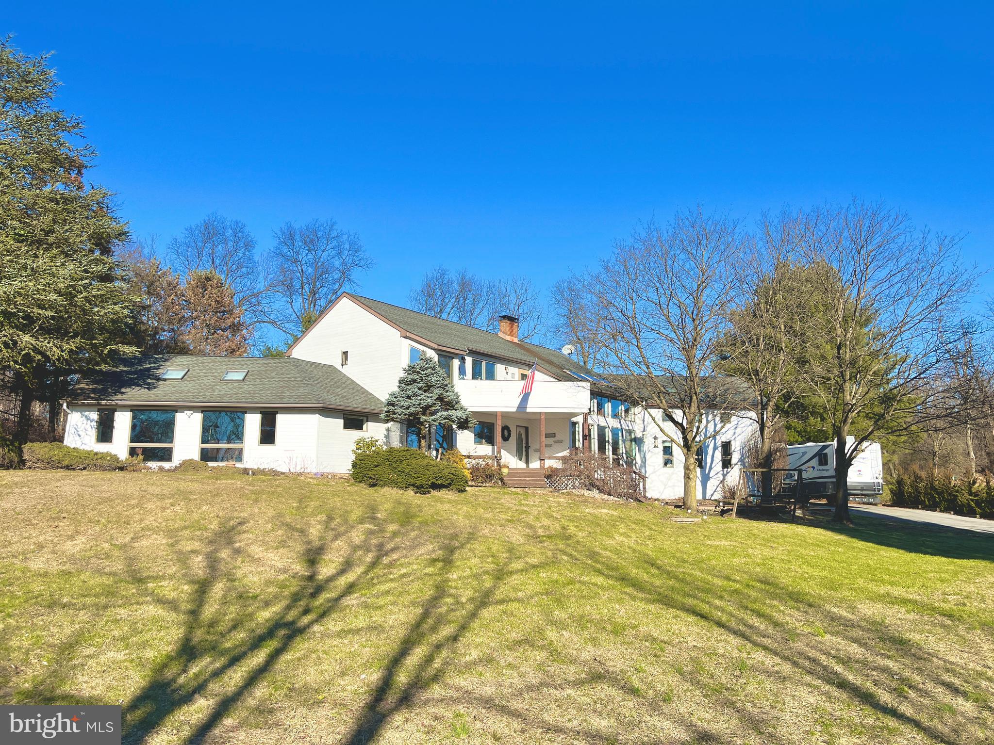 Spacious 3,568 Sq. Ft. custom contemporary home situated on a 1.087 acre cul-de-sac lot in the popular East Penn School District. There is an additional 780 Sq. Ft. of daylight living space in the lower level offering a recreation room, multi-purpose room plus additional storage area. The first floor welcomes you with soaring ceilings, walls of glass, and abundant natural light, setting the stage for elegant living. The renovated chef’s kitchen showcases rich Brazilian granite, premium stainless-steel appliances, and a 5-seat breakfast bar, flowing seamlessly into a sunlit breakfast area and a dramatic two-story dining room. The formal living room, with its floor-to-ceiling windows and vaulted ceiling, creates an inviting space for entertaining. A spacious guest suite offers comfort and privacy, while a stylish powder room and convenient laundry room complete this thoughtfully designed main level.The second floor features a dramatic hallway overlook to the two-story living room, accented by striking wood beams. A bright loft with three skylights opens to a spacious 20' x 15' deck, perfect for relaxing or entertaining. The luxurious primary suite offers a private balcony, expansive walk-in closet, and spa-inspired bath. Two additional bedrooms include a generously sized room currently enjoyed as a craft space, along with an updated full hallway bath. Recently refreshed with a 2025 exterior paint update. This one of kind home blends timeless design with modern comfort.