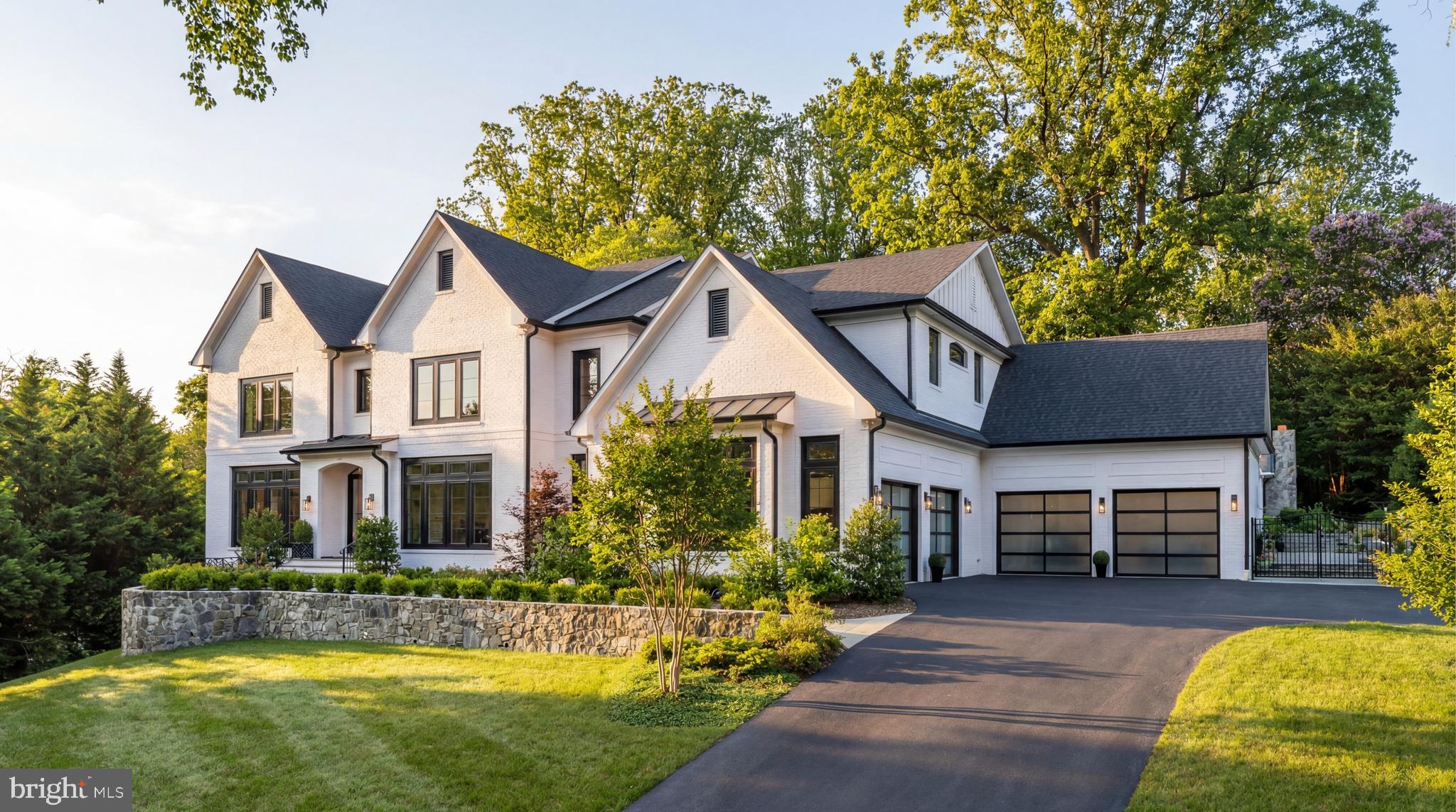 Hidden down a discreet private drive along one of McLean’s most iconic roads, 827 Dolley Madison Boulevard is a custom estate representing the highest caliber in design, materials, and craftsmanship. Constructed in 2021, the immaculate residence rises over its surroundings, its four sides of white brick with dark window trim creating an imperious presence that exudes transitional elegance, both timeless and modern.

A stone retaining wall sets the tone for a harmonious blend of extensive hardscaping and manicured landscaping, all radiantly illuminated after sunset to envelop the setting in a warm glow. A flagstone walkway gracefully leads to double glass front doors beneath a stately portico, opening to a sophisticated plan spanning more than 9,700 finished square feet. Interiors curated by Edith Gregson Design showcase sumptuous selections—Hoppe hardware, Visual Comfort lighting, and wall coverings by Schumacher, Phillip Jeffries, and Temperley London,all integrated with fastidious workmanship and an artful eye.

Formal living and dining rooms flank the reception hall. The living room offers wooded views and gleaming candy-gloss walls, while the dining room dazzles with a lacquered ceiling, Murano blown-glass chandelier, and bold millwork. At the center, an octagonal rotunda soars open to above, anchoring the home with graceful symmetry. A study lined with built-ins doubles as a bedroom suite with full bath. An elevator and powder room are set within the adjoining vestibule.

A grand central staircase, bathed in natural light, separates the informal spaces. The family room features a striking grasscloth coffered ceiling and floor-to-ceiling marble fireplace, opening to a screened porch for year-round enjoyment. The chef’s kitchen is a functional masterpiece, with stacked shaker cabinetry, industrial pendants, and a custom Coppersmith hood above a full Thermador suite. A waterfall peninsula transitions to a sunny breakfast room opening to the rear patio. An amenity-rich mudroom area includes a pantry, laundry, cubbies, a pool bath, and access to the four-car garage.

The primary suite occupies its own wing upstairs, boasting a tray-ceilinged bedroom, wet bar, and balcony. A custom beauty room doubles as a hidden office, while a bespoke dressing room offers dual-tone cabinetry and center island. Two additional walk-ins are each fully outfitted. The marble-clad bath impresses with arched ceiling above a Victoria + Albert tub and walk-in shower. Radiant floors, dual vanities, and dual water closets complete the space. Four additional bedrooms each feature tray ceilings, ensuite baths, and spacious closets. A secondary laundry completes this level.

The lower level, with 10-foot ceilings, is an entertainer’s dream. A walkout recreation room centers the space, with adjacent bar featuring antique mirrored backsplash and a lounge with riveted metal fireplace. Additional amenities include a screening room, fitness center, wine room, sixth bedroom suite, extra laundry, and stylish powder room. State-of-the-art systems include full Lutron lighting, surround sound, Vector security with video monitoring, and advanced HVAC and water treatment.

Outdoors, a bluestone terrace surrounds a 40' x 20' saltwater lap pool with automatic cover, water features, built-in seating, and dramatic lighting. The adjacent cabana features a roaring fireplace with TV above, lounge and dining areas, and a full outdoor kitchen. Beyond, stone tiers cascade to a cutting and herb garden framed by lush plantings.

Just a quarter mile from the GW Parkway, the estate enjoys one of McLean’s most coveted locations, convenient to both Washington and Tysons Corner. Amenity-rich, exquisitely appointed, and designed with impeccable taste, 827 Dolley Madison Boulevard stands as one of the Capital Region’s premier showcases of restrained elegance.