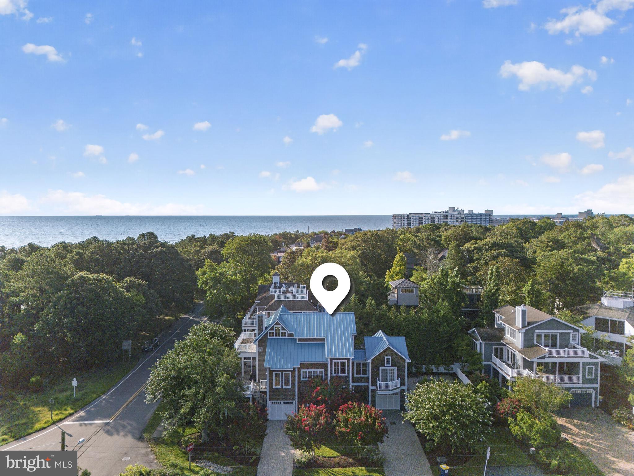 54 Surf Ave delivers it all - Coastal style with all the amenities you desire.  You really can have it all with this rare “in-town” offering: 5 bedrooms, 5.5 baths, elevator, pool, 2 garages, 2 paver driveways, multiple outdoor living spaces, an oversized lot all just steps away from Deauville Beach. This North Rehoboth charmer cannot be duplicated with today’s building codes.  With two true "primary suites,” the remaining 3 bedrooms have en-suite baths for the ultimate guest satisfaction.  The main level features an open floorplan with hardwood floors, a gourmet kitchen, a gas fireplace, wet bar and an expansive deck and covered porch.  The top floor features vaulted ceilings, a large primary suite, gas fireplace and sundeck with glimpses of the Atlantic Ocean. The Gunite pool is surrounded by a paver patio, lovely landscaping and an updated outdoor shower. Beach in the morning, pool in the afternoon and the sound of ocean waves to lull you to sleep.  What could be better?  Recent updates include a new standing seam metal roof, new water heater, updated laundry center and all new decking.  Sold furnished.