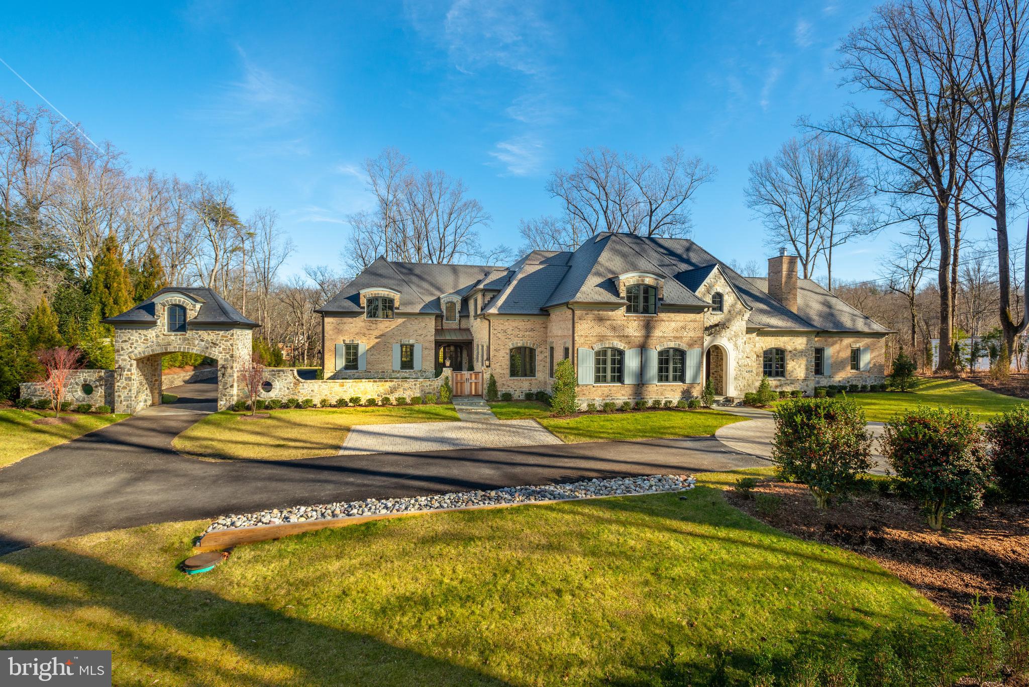 New Price! Have the perfect spring and summer in this fantastic new home with exceptional outdoor living spaces that include a heated Pool, Loggia, Terrace with Pergola, lush Lawn and Gardens This new world-class residence is on a surprisingly private, wooded homesite just minutes to DC! Walking distance to nature paths. The gorgeous French Country Estate with Stone and Brick facade is where classic elegance meets modern luxury and attention to detail is evident in every inch both inside and out. The Main Level is open with intimate spaces and arched openings with! The gracious entry leads to a Gallery from the Master Suite to the Home Office, Caterer s Kitchen and Pantry connecting the Library, Great Room, Dining Room, amazing Kitchen & Breakfast Area with cozy Family Room. The Family Room has a 2-sided Stone Fireplace leading to the Loggia overlooking the fantastic backyard outdoor space. The Second Level has a charming family Loft area,  grand Guest Suite and 3 additional en suite Bedrooms. The superbly designed Lower Level with a generous Recreation Room has an enormous 2-sided Fireplace that allows an intimate seating area on one side and a Bar with Wine Cellar behind and Game Room on the other. The Lower Level also includes a Media Room, Gym with glass doors all around, Bedroom and Full Bath. The front exterior of the property is thoughtfully designed with a circular driveway that has stone paver detail, flagstone lead walk to the front door, extra parking area, a Porte Cochere to Motor Court and 4-Car Garage. There is a custom gate to the vestibule and second entrance door to Mud Room. . This extraordinary property is a magnificent collaboration of Harrison Design Architects, Artisan Homes and Charles Owen of Fine Landscapes with access to private trails to walk to Pimmit Run and the Potomac River.