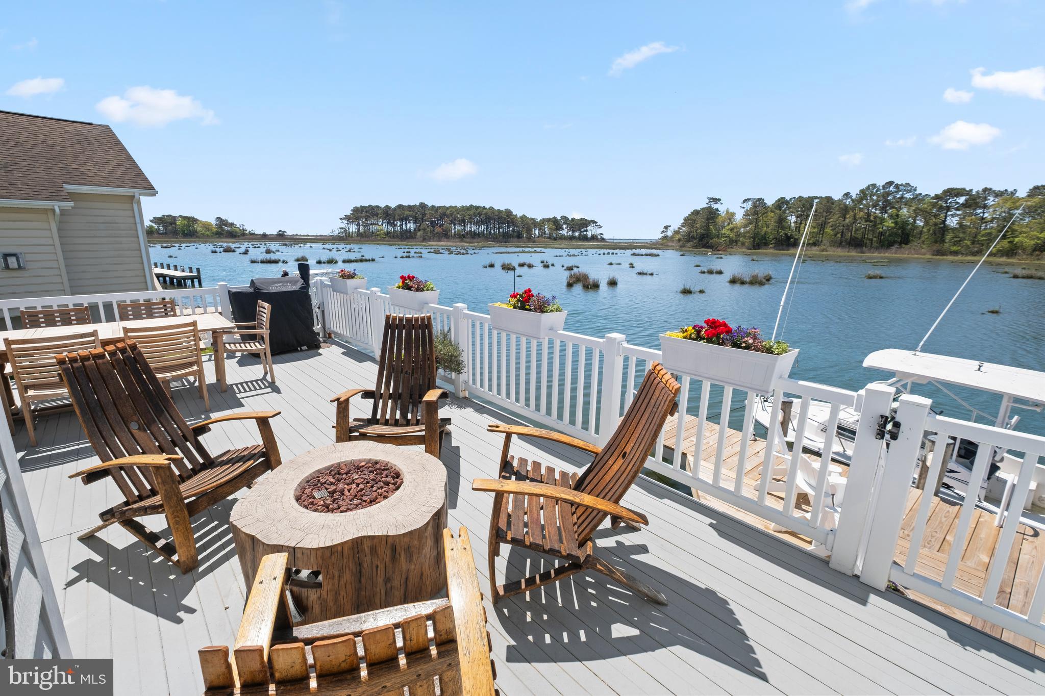 Wake up to open water. From the moment you step inside 12704 W End Ct, the bay commands your attention — unobstructed, panoramic, and entirely yours. Tucked in coveted West Ocean City with no HOA, this custom-built bayfront retreat delivers over 4,300 square feet of thoughtfully designed coastal living, a private dock, and the kind of views that never get old.

Inside, the vaulted great room with powered blinds sets the tone — open, airy, and flooded with natural light. The chef’s kitchen is built for entertaining, while the main-level primary suite offers a private retreat without ever leaving the first floor. Multi-zone heated tile floors, a secret bonus room, and a dramatic crow’s nest balcony with ocean views round out an interior that’s as functional as it is impressive.
The smart home features are equally refined: WiFi-enabled thermostats, invisible in-wall speakers, dock lighting, and a Tesla charger — all integrated seamlessly into the coastal aesthetic. A remote-controlled retractable awning, whole-yard irrigation, architectural uplighting, and pre-wired generator backup complete the picture.

Step outside to your private dock and feel the pace shift immediately. Whether you’re launching a boat at sunrise, watching the pelicans from the deck, or catching the inlet lights at dusk, this home is designed for life on the water. And with no HOA, you’re free to enjoy it entirely on your terms.

Homes like this — true bayfront, custom-built, move-in ready — rarely come available in West Ocean City. This is your moment.
