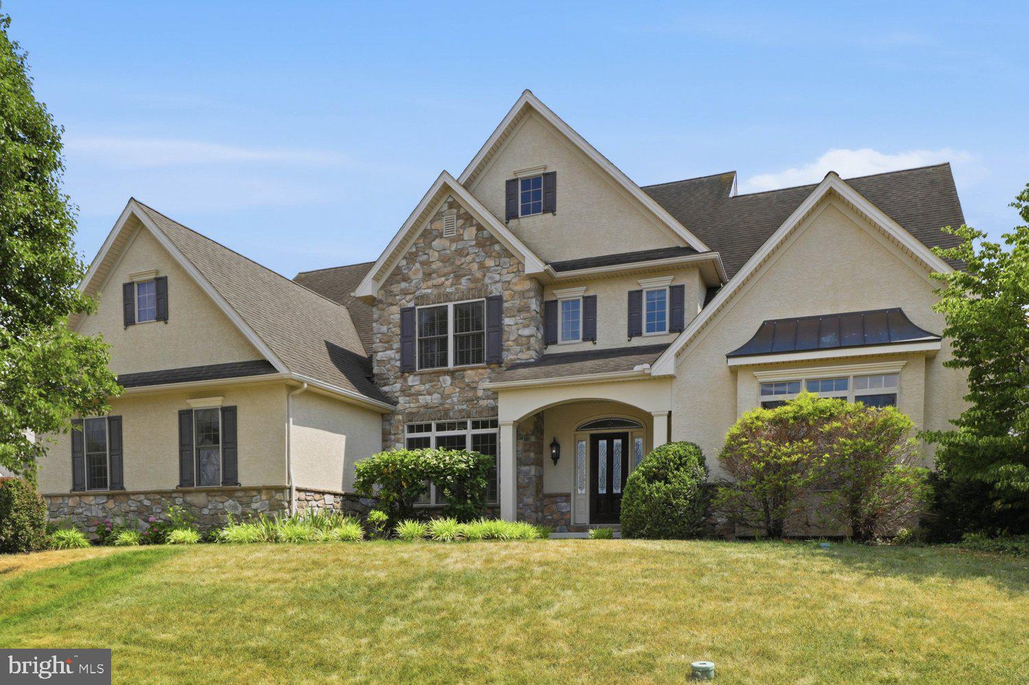 Stunning custom-built residence showcasing timeless architectural details, exceptional craftsmanship, and refined finishes on a spacious corner lot in the highly desirable Penns Crossing community in Manheim Township. This impeccably maintained move-in-ready home offers 4 bedrooms, 3.5 baths, and a 3-car garage, blending classic elegance with modern comfort. A gracious foyer welcomes you into a thoughtfully designed floor plan featuring a formal dining room with detailed trim work, a private office with custom built-ins, and a first-floor guest bedroom with access to a full bath—perfect for guests or multigenerational living. Designed for both everyday living and effortless entertaining, the gourmet kitchen features an oversized center island, granite countertops, abundant cabinetry, under-cabinet lighting, and a wet bar. The kitchen opens seamlessly to the spacious family room, where a gas fireplace and custom built-ins create a warm and inviting gathering space. Rich hardwood flooring extends throughout most of the main level, while tile flooring enhances every bathroom. Fresh interior paint, extensive crown molding, abundant natural light, and a premium retractable central vacuum system further elevate the home's appeal. Upstairs, the expansive primary suite offers a relaxing retreat with a sitting area, spacious walk-in closet, dual vanities, and an oversized tiled walk-in shower. Two additional generously sized bedrooms and a full bath complete the second floor. The finished lower level adds exceptional versatility with custom cabinetry, a kitchenette complete with cabinetry, refrigerator, sink, and microwave, plus a full bath. Whether used as a media room, recreation area, guest suite, fitness room, or entertainment space, this level adapts effortlessly to your lifestyle. Step outside to a screened porch overlooking a private patio and beautifully hardscaped backyard surrounded by mature landscaping and colorful seasonal blooms—an ideal setting for relaxing or entertaining. Offering timeless design, exceptional craftsmanship, thoughtful upgrades, and an outstanding location, this distinguished Penns Crossing home is designed to impress at every turn. Schedule your private showing today!