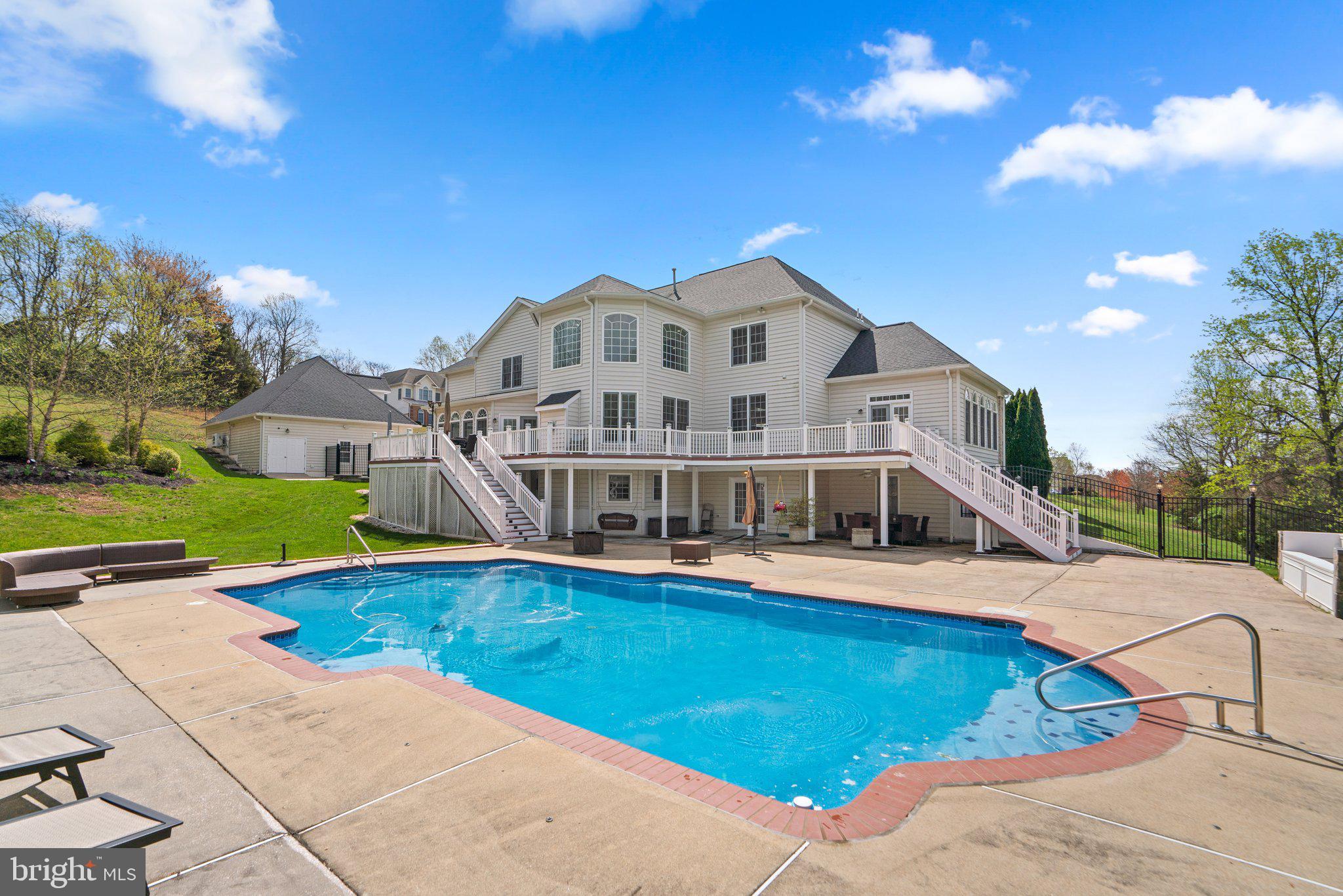 This home has it all!  With over 10,000 square feet of finished space and room to grow, this could be your forever home.  Imagine the bucolic drive down scenic roads on the way back to your stately, all-brick colonial perched upon a hill at the end of the culdesac with a circular driveway, detached 3 car garage, heated swimming pool, and 3 acre, fully fenced yard.  Every upgrade in this home has been thoughtfully planned and it has been meticulously maintained from the updated kitchen and baths, to the fully finished lower level with theatre, game room, wet-bar and au-pair suite.  The main level features a 2-story foyer, 2-story family room drenched in sunlight, huge breakfast room, formal dining room, office with classic cherry wood built-ins, 2nd stair case, and solarium or playroom.  Hardwood floors are throughout the main and upper levels.  The primary bedroom suite is a retreat in itself with luxury bath, soaking tub, double vanities, and massive sitting room with endless storage.  Four bedrooms on the upper level with 3 full baths and the lower level includes 2 additional bedrooms with 1 full bath and walkout to the heated pool, patio, and tiki bar.  Everything in this home is SMART and maintenance free from the Trex deck to the pvc trim and remotely controlled Lutron lighting system, pool functions, alarm system, speakers (indoor and outdoor) and garage doors.  Control not just the lights being on and off, but also the color of the lights directly from your smartphone.   Enjoy entertaining, sunsets, or drinking a glass of wine from the privacy of your expansive deck which overlooks the yard and playground with rubber mulch.  If you like the entertain or cook outside, you will surely enjoy the tiki bar with power, water, and an additional gas line connection.  With garage parking for up to 6 cars, the oversized 3-car detached garage has a finished upper level and also has the ability to be converted into an apartment or au-pair suite with water, sewer, and utility connections already in place.  You don’t want to miss this masterpiece!!
