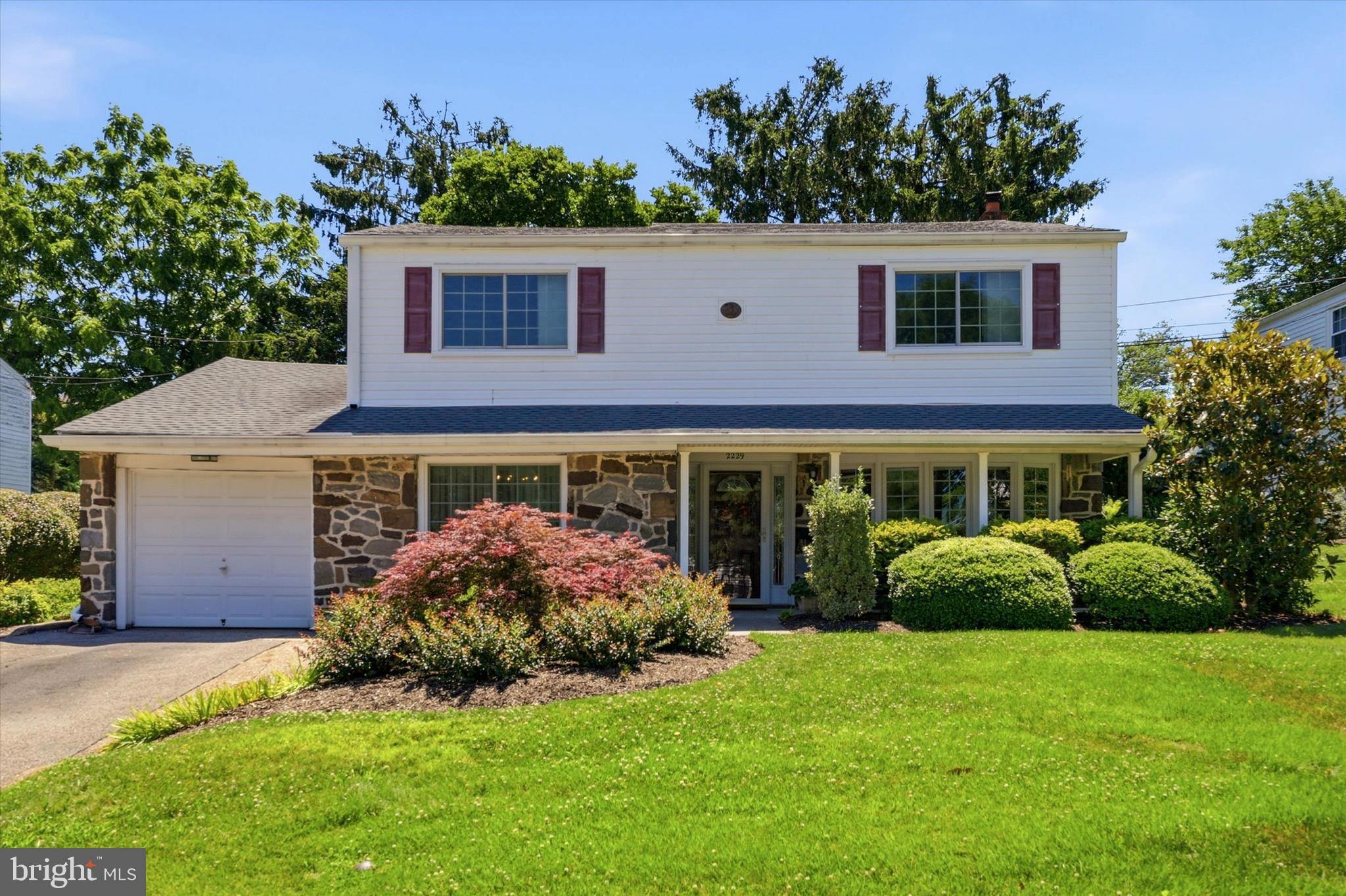 Welcome to this charming four bedroom, 2.5 bath home in Lafayette Hill that offers touches of popular mid-century modern design, functionality and an unbeatable location!  A covered front porch greets you as you step inside to find a bright living room with gorgeous bay window,  gracious dining room accented with chair rail, a cozy, fireside family room with gas fireplace and the heart of the home – a  wonderful, renovated kitchen boasting abundant 42 inch cherry cabinetry, Corian counters, stainless steel appliances, under cabinet and recessed lighting and a breakfast area that overlooks a gorgeous rear yard. A large laundry room, powder room and roomy hall closet are also on the main level.  Head upstairs  to discover the spacious primary suite offering a walk-in closet and private bath.  Tastefully updated primary and hall baths provide a fresh, contemporary feel with designer tile and granite counters while seamlessly blending with the home’s charm and character.  Three more generously sized bedrooms, each with excellent closet space, complete this level.  Hardwood floors throughout much of the home including under the carpet in the bedrooms.  Step outside to enjoy the many birds who visit and the serenity of the professionally landscaped rear yard where boulders and specimen plantings create a stunning setting.  Additional amenities include roof and gutter replacement in 2019, gutter guards, new heater in 2021, one car attached garage, basement with plenty of storage space, replacement windows and custom shades and blinds.  With easy access to schools, parks, dining, major arteries and shopping centers, this home combines accessibility with the warmth and connection  of an established community.  Desirable Colonial School District.  One Year Home Warranty to Buyer at the time of settlement.   See it today because homes like this  go quickly!
