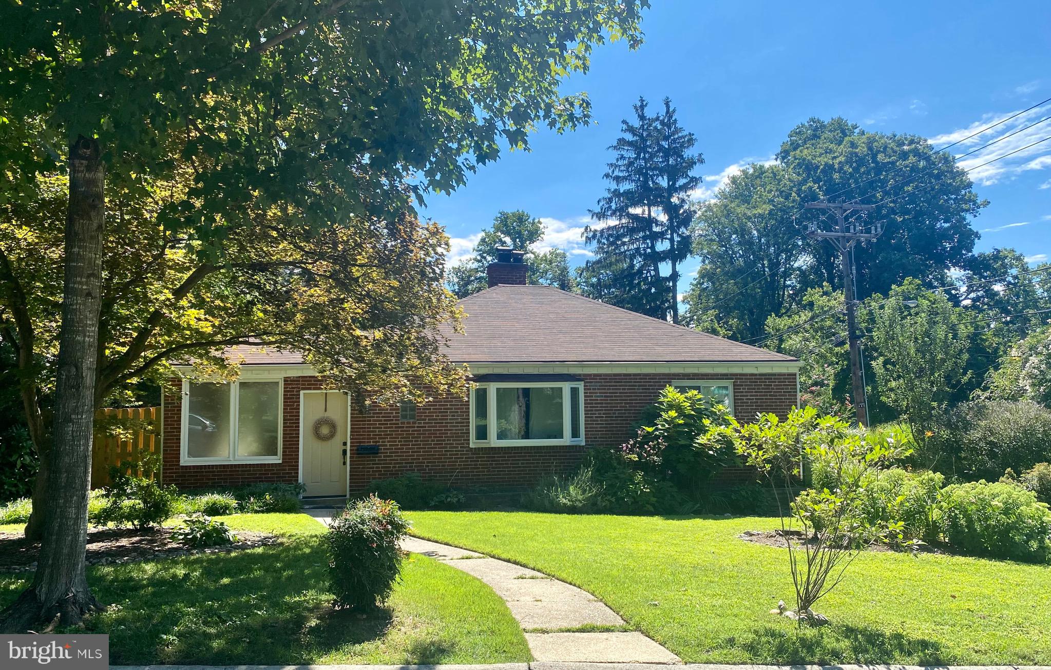Welcome to 9901 Markham St., a mid century gem on a gorgeous corner lot in the highly
desirable neighborhood of Chalfont in the Four Corners area of Silver Spring, less than a
mile from HolyCross Hospital, Sligo Creek Park and close to Forest Glen
Metro. This solid brick home with a deep and wide driveway and carport/garage offers ideal
one level living. A charming entry hall with custom shelving and cabinetry  welcomes you to the light-filled living room with a fireplace, front bay window, and dining room with custom shiplap wall and large window with view of private patio. The sunny kitchen has table space, granite countertop and new appliances, the updated bathroom has a jetted tub and stunning custom tilework.  The home office with a privacy windows and sliding glass door is an added bonus.  The spacious laundry/utility room with front loading washer and dryer has  pull down stairs to generous attic storage area. Many special features  including gleaming hardwood floors, newer windows, and custom blinds throughout. Beautiful outdoor space! Professionally landscaped with hardscape accents and a private rear yard with fencing and table space patio area near the garden. This property is in beautiful condition and offers many opportunities to either move-right in or great rental income as an investment and comes with the possibility of owner financing too! Open house this Sunday from 2-4 with savory and sweet treats from District Cafe. Great value! Don't miss this special home and property!