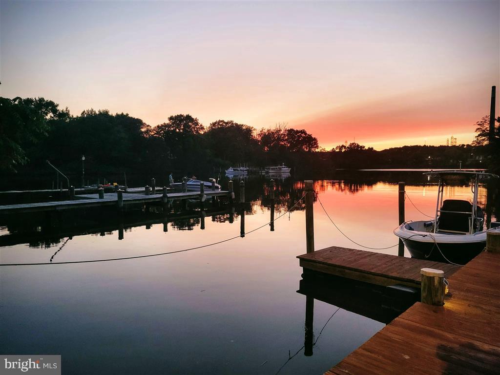 Live your dream with this Deeded Waterfront home with beautiful sunsets! Amazing large Tiki Bar is on the waterfront cement Deck with 2 cranes. There is a Wood dock and floating dock for your boat, jetski, and kayak fun, and is located on the calm Cox Creek. Jump in your boat and be on the Patapsco River, at the Chesapeake Bay, or Inner Harbor quickly. If you enjoy fishing, anchoring out with other boaters,swimming, or going to restaurants by boat with friends, you are in a central location.  Enjoy night boat rides with the commercial building lights to guide you back into the creek and the ambiance of the lights reflecting off the water.

* This home has extensive water views from 14 windows and doors; decks, and Tiki Bar Paradise. This home is ENERGY EFFICIENT with NEW Heat pump HVAC 2018. Original cottage converted 1960. Major addition in 1996 and substantial additions and alterations in 2013.  Since then new roofs, siding, kitchen, and bath renovations includes 5 bedrooms, Walk in closet, 2.5 baths (one with XL Soaking Tub), 3 levels of living rooms, Custom Kitchen, Dining room, and extensive basement and attic storage. *NEW LVP FLOORING & PAINT*  

This fully renovated house has a beautiful streetside covered concrete porch with lit half moon window and large back deck over a shed. Street side detached 20 foot wide dual garage with upper storage of 460 SF, plus basement of 576 SF totals **3,628 SF**.

Great IN-LAW APARTMENT* on lower WALK OUT level to the water is well situated for multi-generation and large families, or RENTAL INCOME level with boat slip is in high demand.  
 
This RARE FIND is located in quiet Orchard Beach waterfront community in *Anne Arundel County* with a charming PRIVATE COMMUNITY BEACH and ramp on Stoney Creek only a few blocks away. There is NO mandatory association fees, and NO flood insurance needed. 

Waterfront Living with your own Tiki Bar cant be beat for this small investment.  Riparian Rights here (unlike much of local waterfront in which the community owns waterfront) so you have full waterfront privacy at your personal Tiki Bar!  Indulge in your serene waterfront dream!