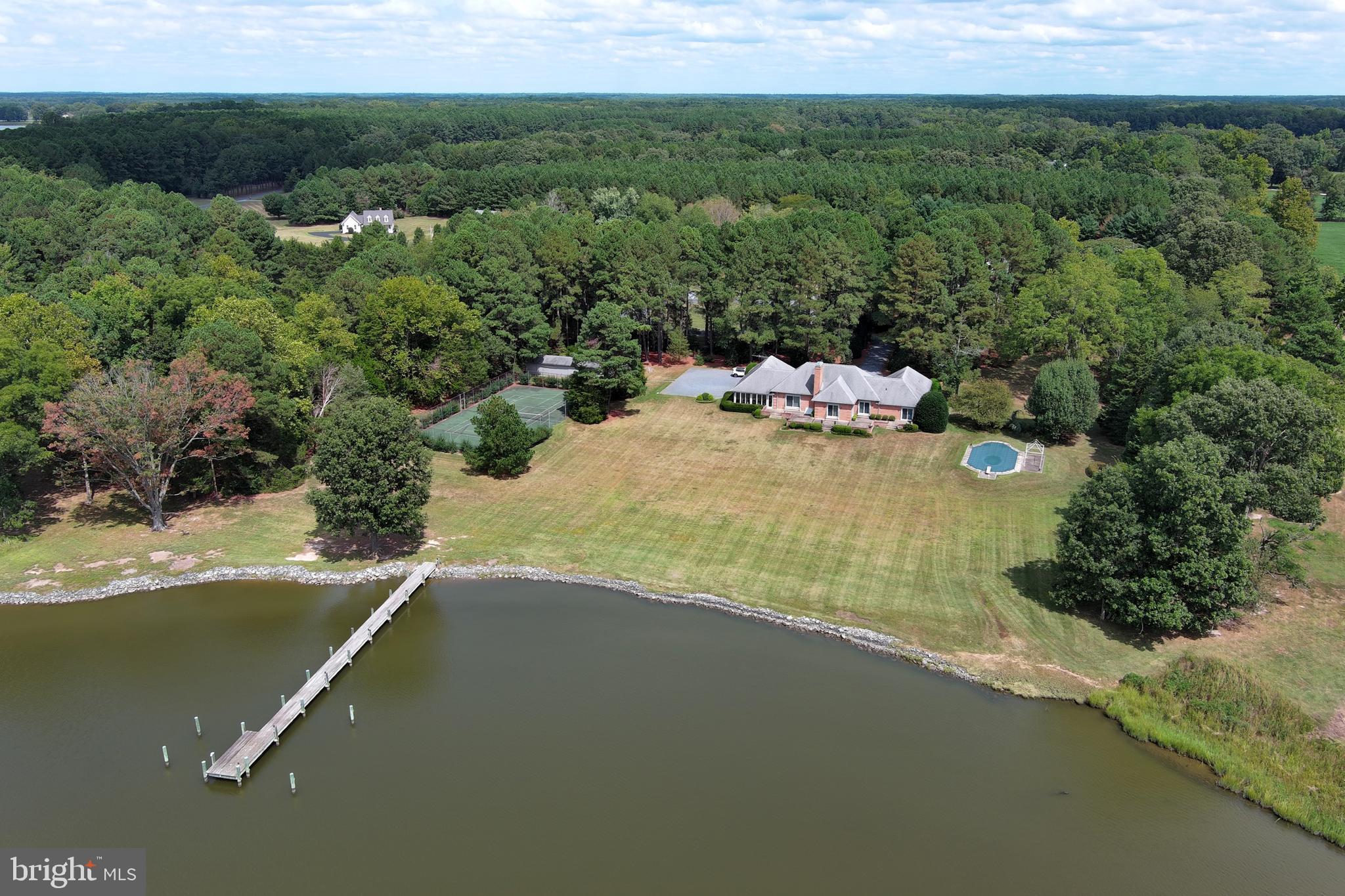 Welcome to Holly House, an exceptional French Provincial-inspired estate gracefully set on 5 spectacular waterfront acres along the Miles River. This impeccably constructed one-story brick residence offers sweeping panoramic water views and breathtaking sunsets from an idyllic setting designed for both relaxation and entertaining.
The property's outstanding amenities include a waterside swimming pool, private pier, expansive rear terrace, tennis court, and an oversized outbuilding offering abundant storage or flexible use. A rare opportunity to own a distinguished waterfront retreat where timeless architecture and exceptional outdoor living come together in one remarkable setting 
Incredible opportunity to refresh or do major remodel to make this your forever home.
currently a 3 BR septic but was just approved for a 5 BR
In addition Full architectural plans available Price on request and could be adapted to buyers specs